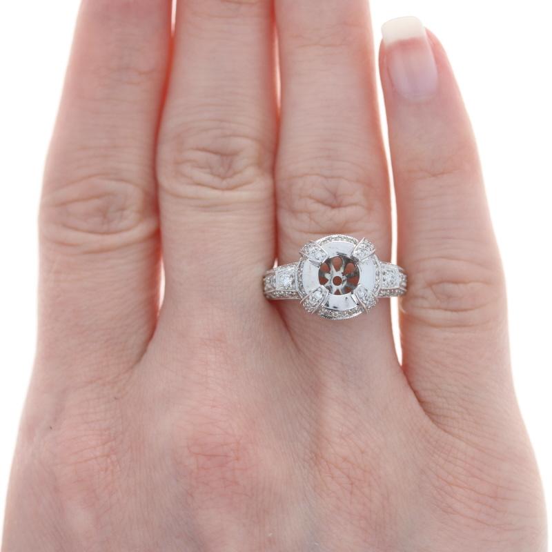 Absolutely breathtaking, this NEW semi-mount ring will be the perfect piece to display your treasured engagement or heirloom solitaire! This 18k white gold ring showcases a sophisticated halo design that is adorned with a sparkling collection of