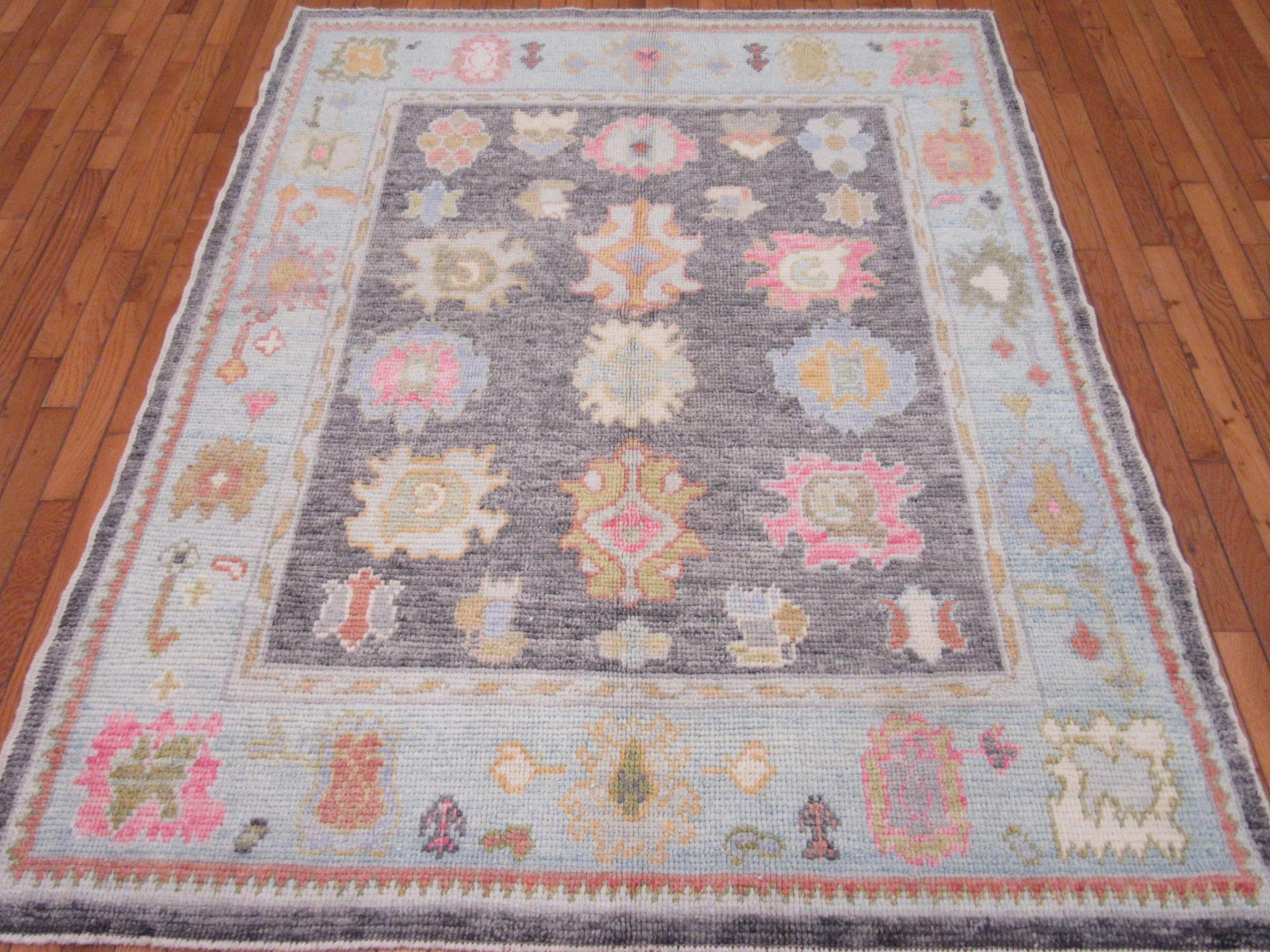 This is a new hand knotted Oushak rug from Turkey. It is made with fine Turkish wool colored with natural dyes. It measures 5' x 6' 3'' which can be used in just about anywhere in your home bringing color and life to the spot.