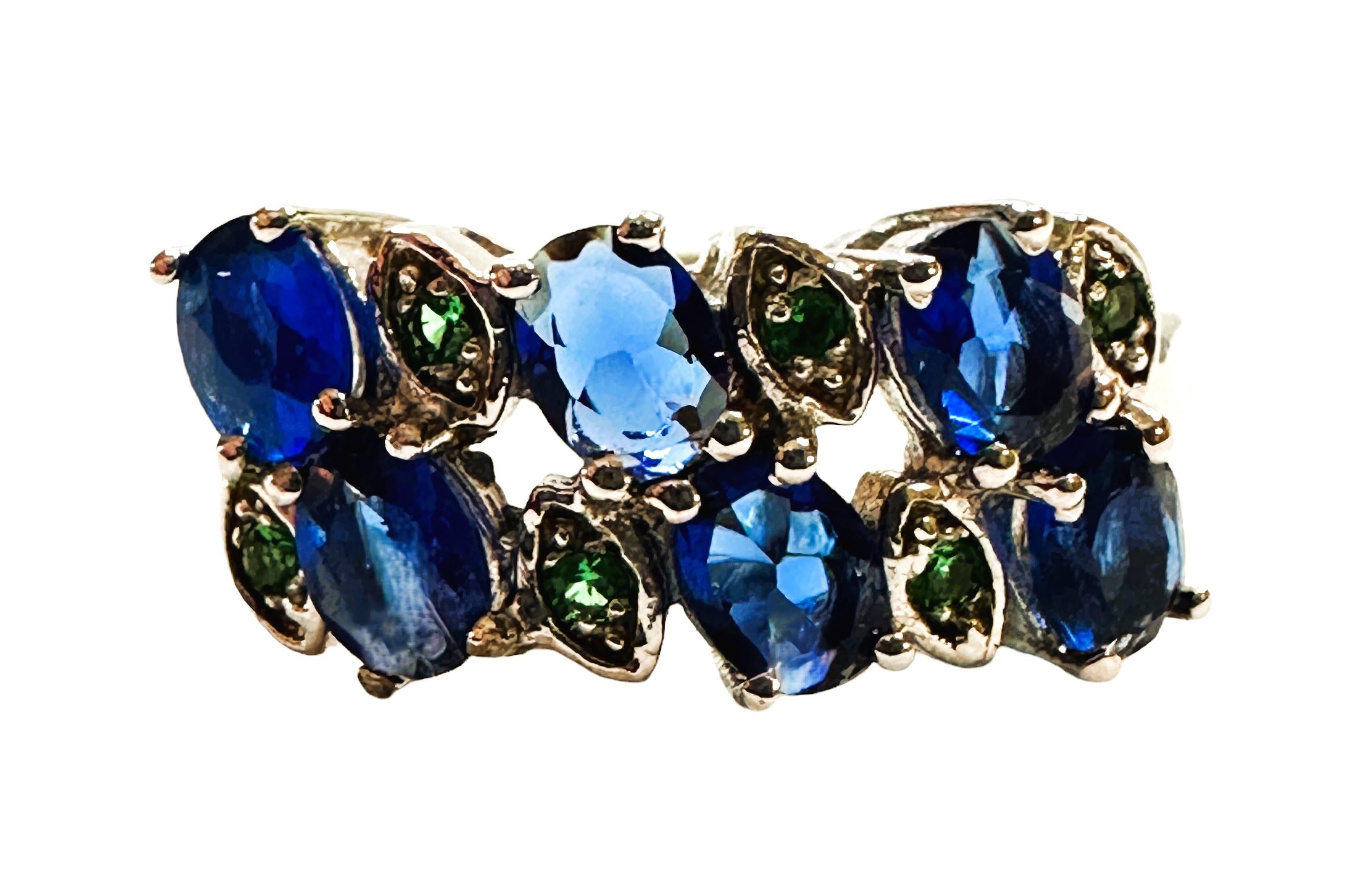 L'anello misura 8,25 e ha 6 bellissime e brillanti pietre di zaffiro.  Sono pietre di alta qualità.  Le pietre sono di taglio ovale per un totale di 1,50 carati.  Misurano 4 x 3 mm.  L'anello ha anche 6 pietre di Tsavorite a taglio rotondo che
