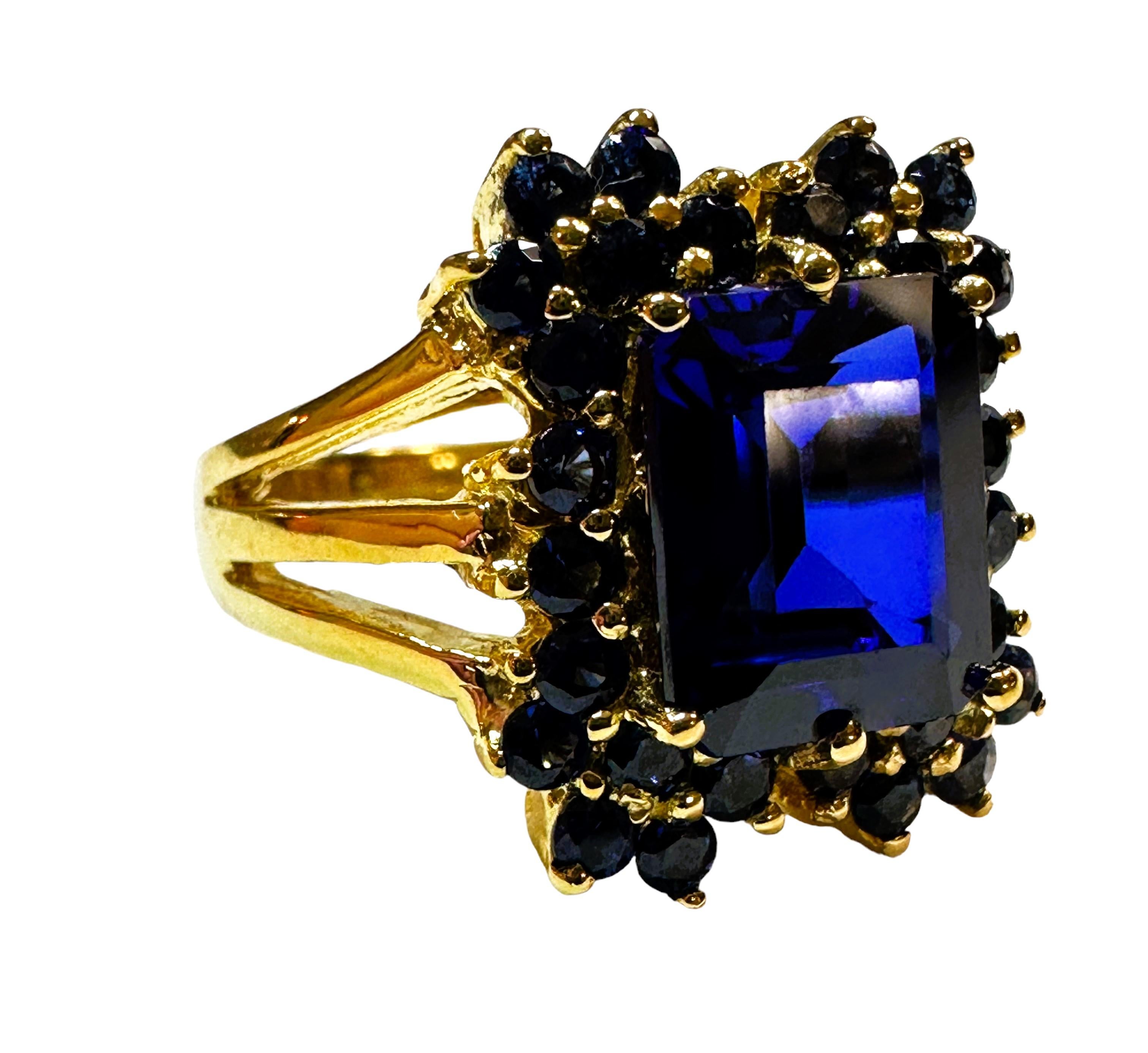 Der Ring ist eine Größe 6,25 und ist einfach atemberaubend  Es ist ein hochwertiger Stein.  Der Stein ist ein Smaragd-Schliff Stein und ist 4,70 cts.   Es misst 9,8 x 7,8 mm.  Der Stein ist von blauen Saphiren im Diamantschliff umgeben.  Das wird