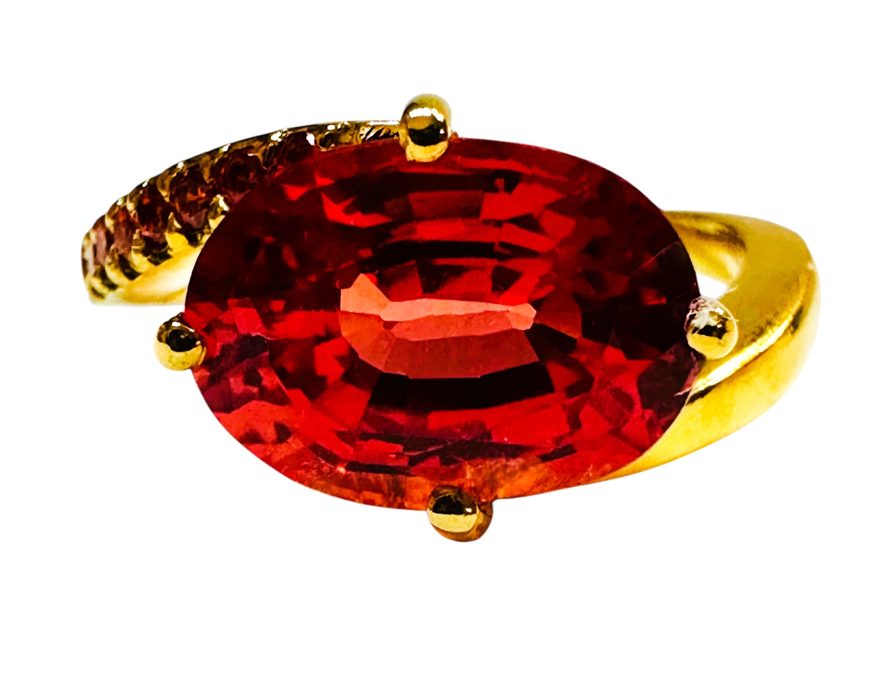 I just love the beautiful colors this ring has!  The ring is a size 7.   It is from Sri Lanka and is just exquisite.   A very high quality stone. It is an oval cut stone and is 5 Cts.   The main stone is 11 x 8 mm and has diamond cut orange