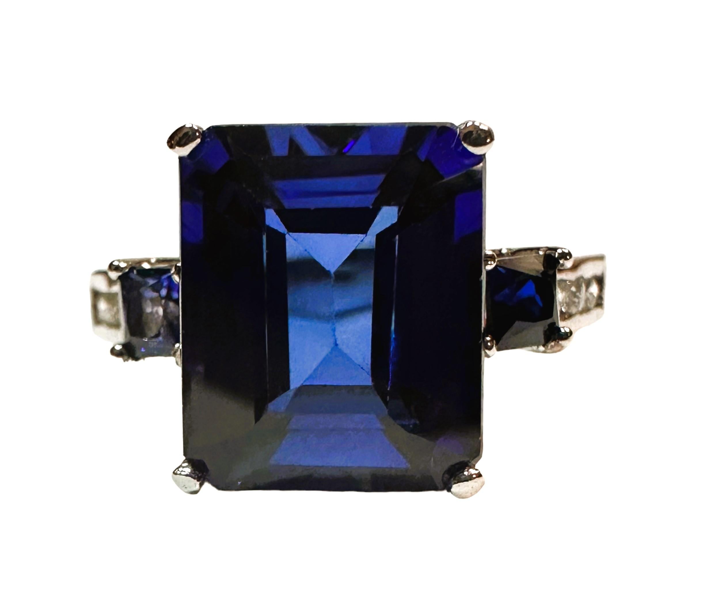 Der Ring ist eine Größe 6.25 und hat nur eine schöne und brillante Saphir Stein.  Es ist ein hochwertiger Stein.  Der Stein ist ein Smaragdschliff Stein und ist 6.0 cts.   Er misst 10,8 x 9 mm.  Der Stein hat 2 Kissenschliff  blaue Saphire auf jeder