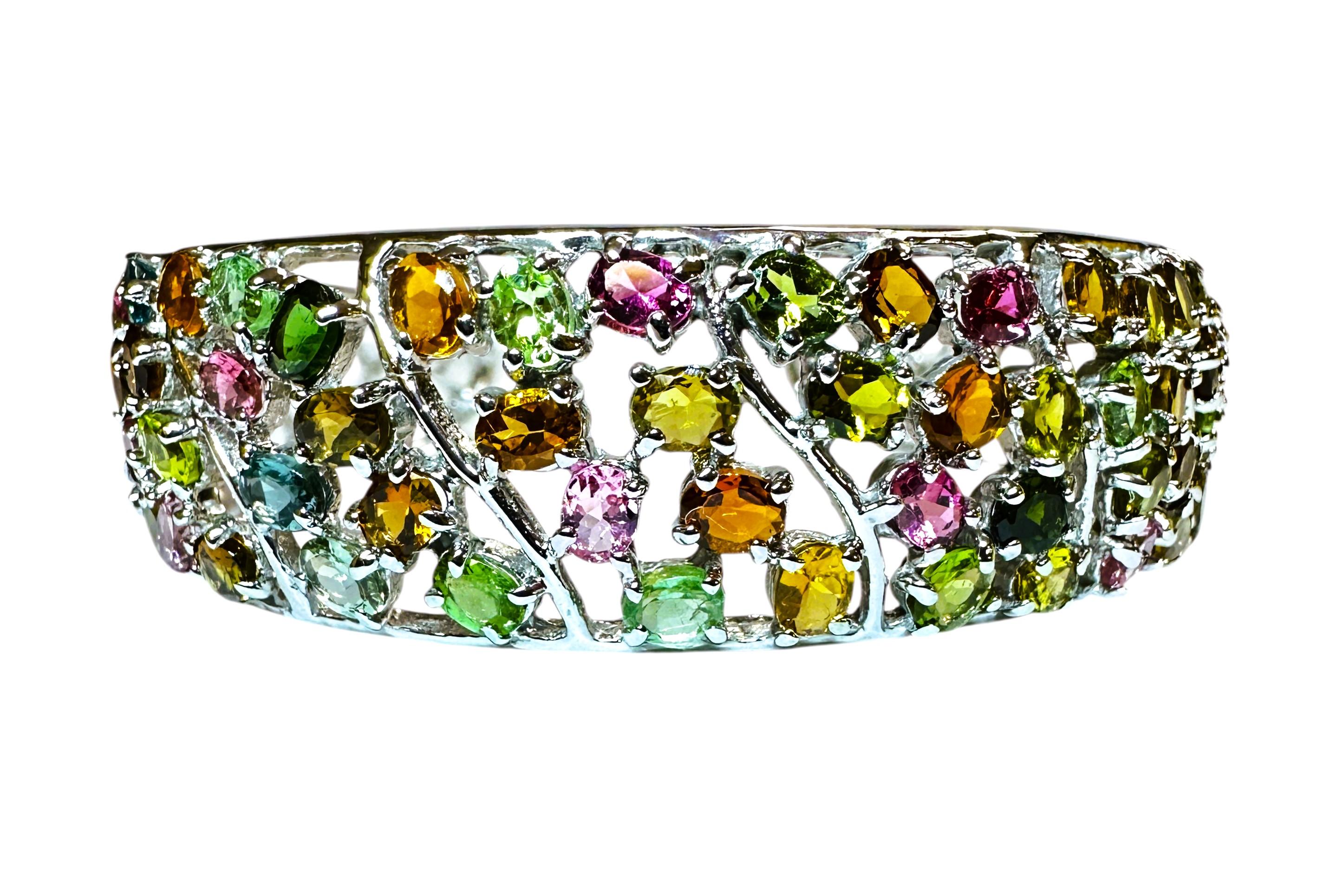 This bracelet is really beautiful.  It's truly a glamorous statement bracelet.   The stones are from Brazil and they are both round and oval cut stones. They are tourmalines and citrines.     It measures 2.5 inches across and is 17 mm wide.  It can
