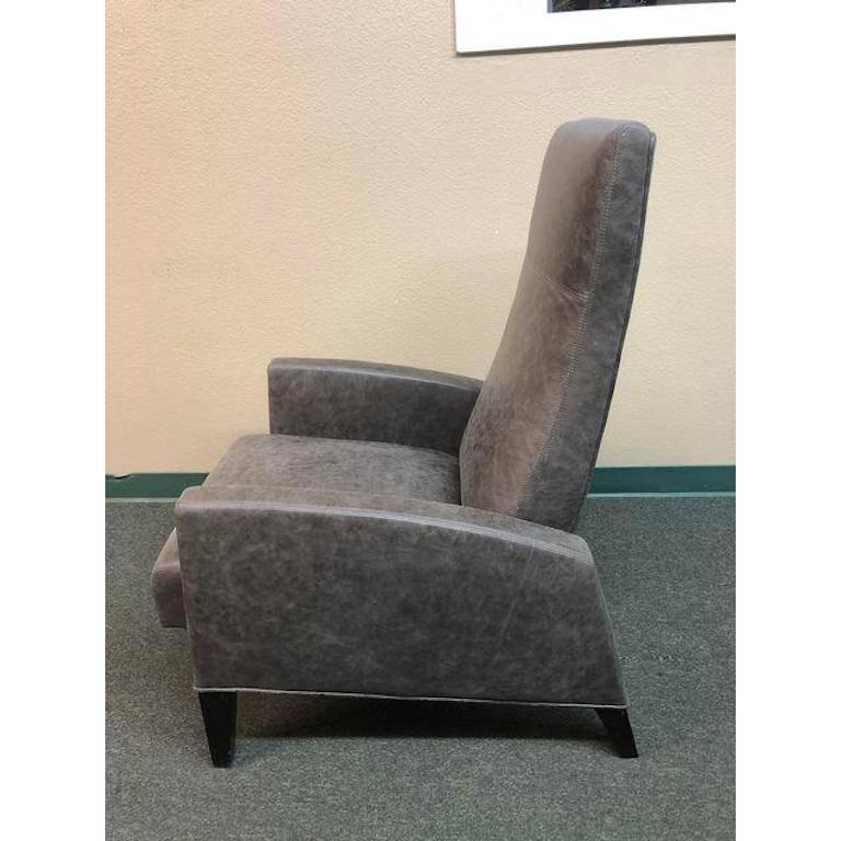 A modern interpretation of a comfy leather recliner. Beautiful distressed grey leather with double stitching shown in a contemporary Silhouette that is just as elegant upright as it is comfortable when reclined. An easy, manual push mechanism.