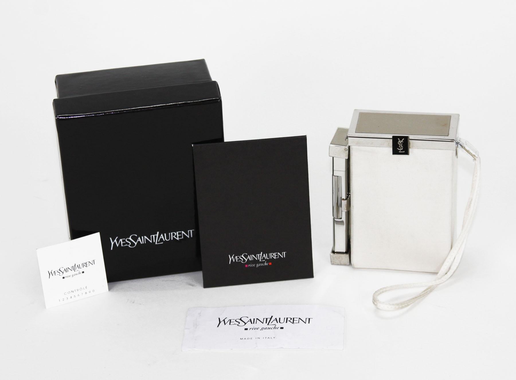 Tom Ford for Yves Saint Laurent 
Spring/Summer 2001 Collection
An Yves Saint Laurent white silk cigarette case and lighter. This item features a chrome tone latched hinged top that opens to a space suitable for a pack of cigarettes. Another latched