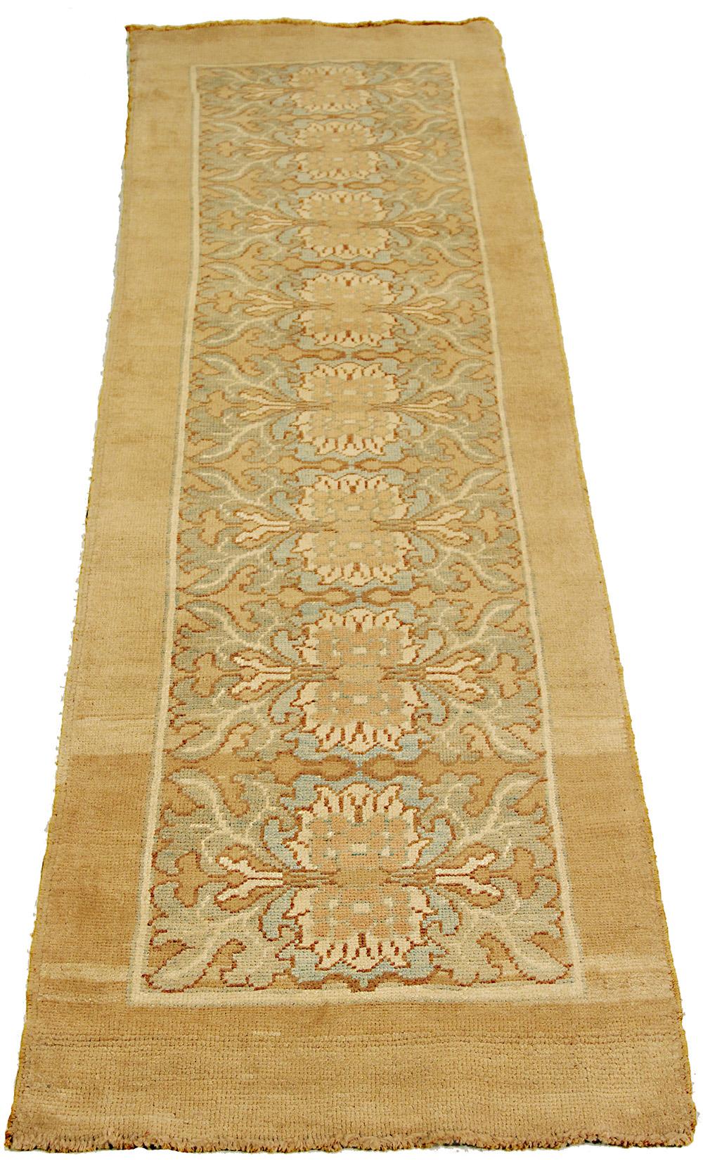 New handmade Turkish runner rug from high-quality sheep’s wool and colored with eco-friendly vegetable dyes that are proven safe for humans and pets alike. It’s a Donegal design showcasing a beige field with blue, ivory and green floral details.