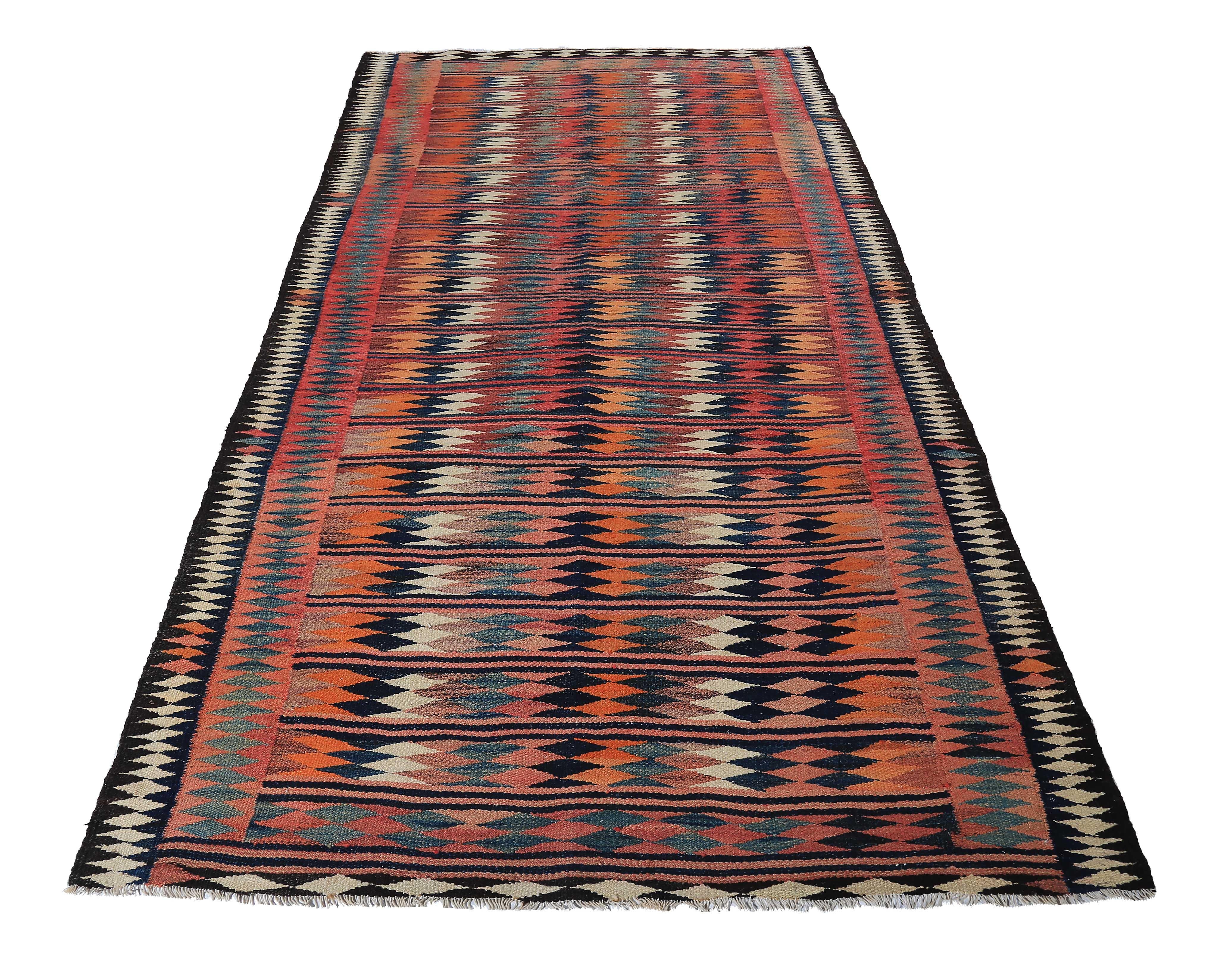 Turkish rug handwoven from the finest sheep’s wool and colored with all-natural vegetable dyes that are safe for humans and pets. It’s a traditional Kilim flat-weave design featuring colorful geometric details on a rich black field. It’s a stunning