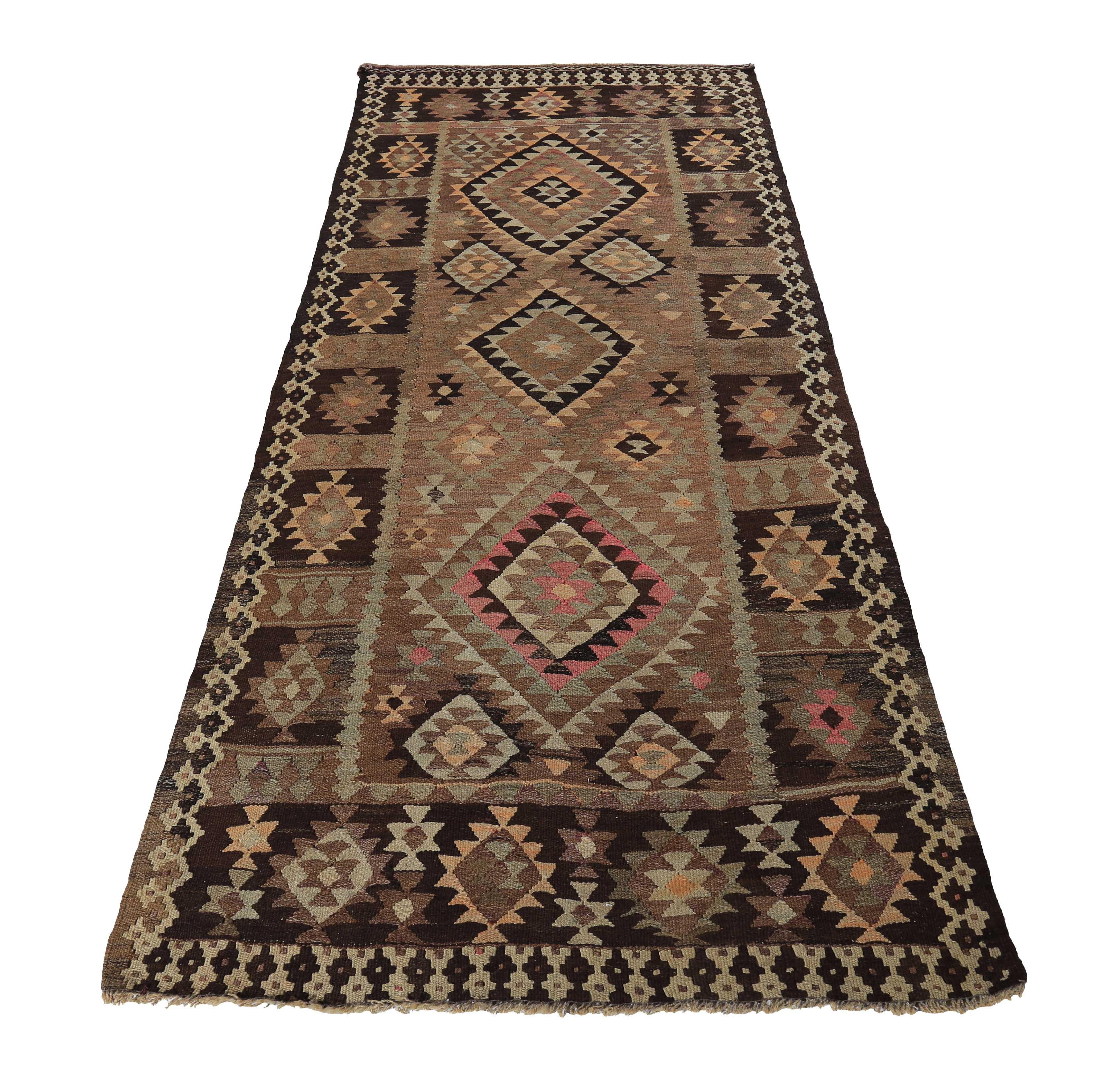 Turkish rug handwoven from the finest sheep’s wool and colored with all-natural vegetable dyes that are safe for humans and pets. It’s a traditional Kilim flat-weave design featuring pink and ivory medallions on a rich brown field. It’s a stunning