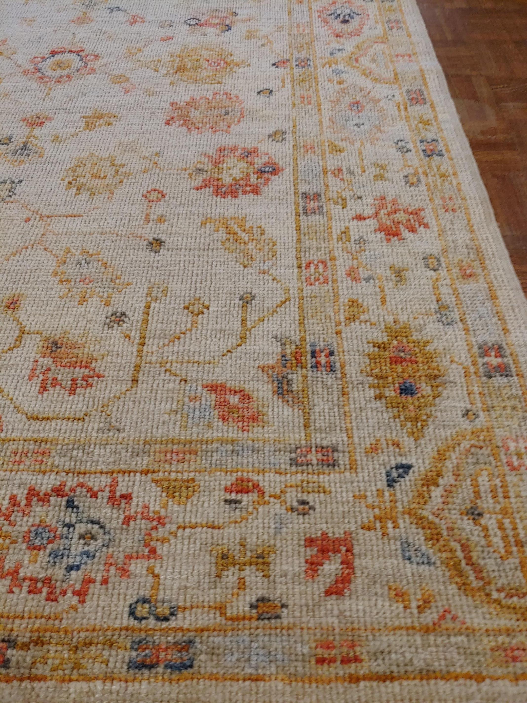 This is a new Turkish Oushak with all of the wonderful colors of the antique pieces. Both the border and field are ivory. It is a wonderful decorator's rug. Measures: 4 x 5-10.