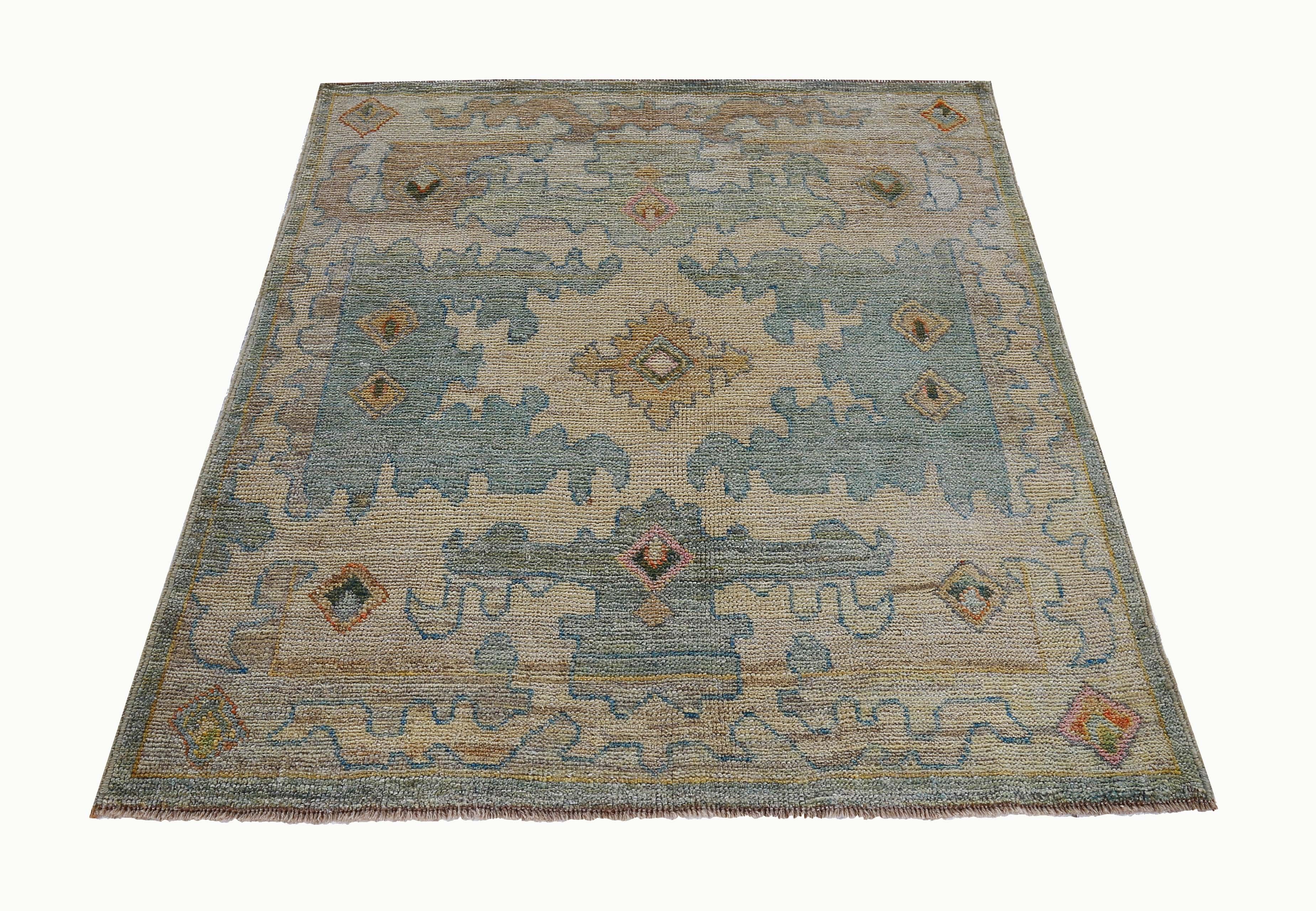 New Turkish rug made of handwoven sheep’s wool of the finest quality. It’s colored with organic vegetable dyes that are certified safe for humans and pets alike. It features floral details in blue and green over a beige field. Flower patterns are
