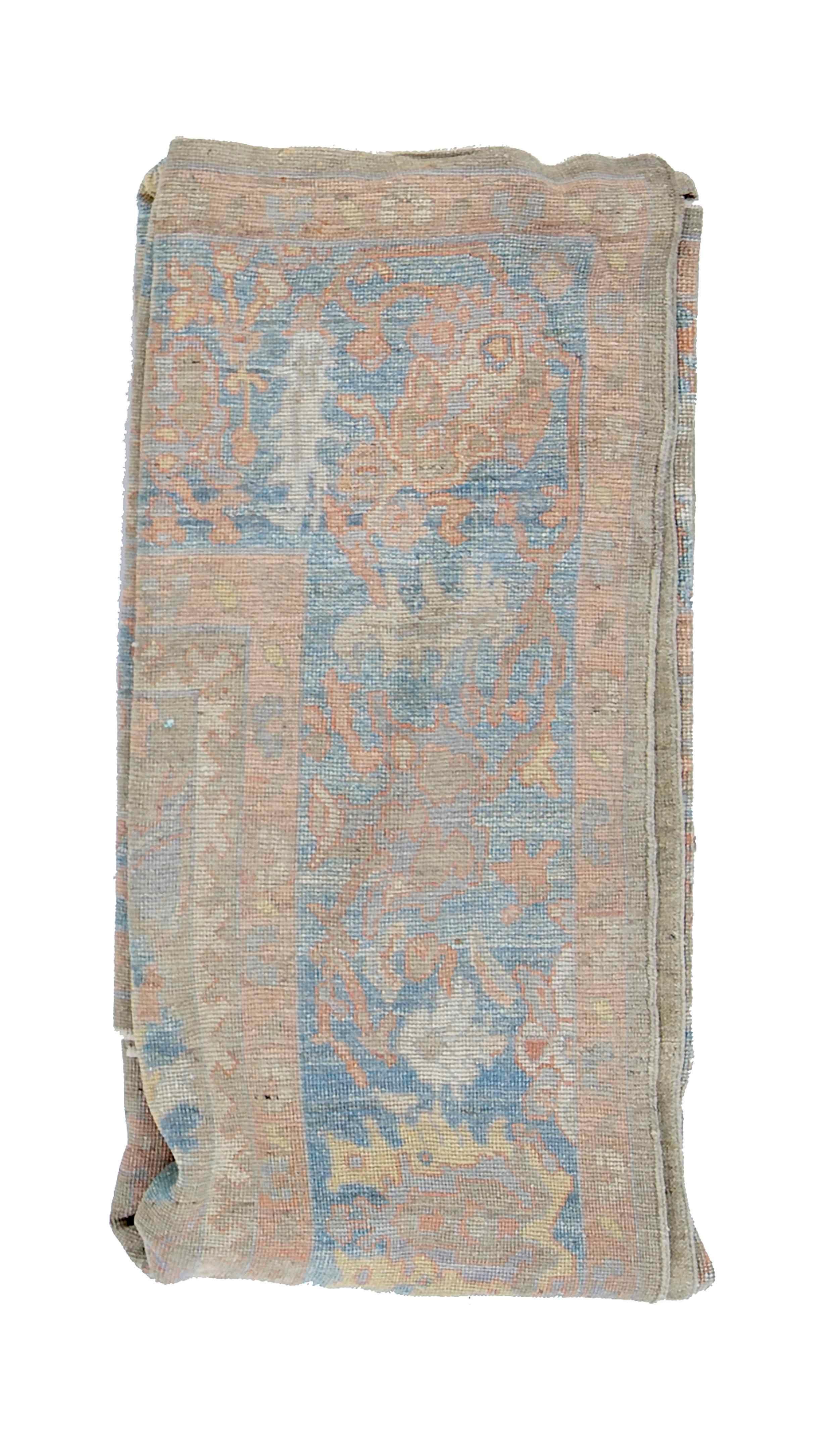 New Turkish rug made of handwoven sheep’s wool of the finest quality. It’s colored with organic vegetable dyes that are certified safe for humans and pets alike. It features floral details in blue and salmon over a gray field. Flower patterns are