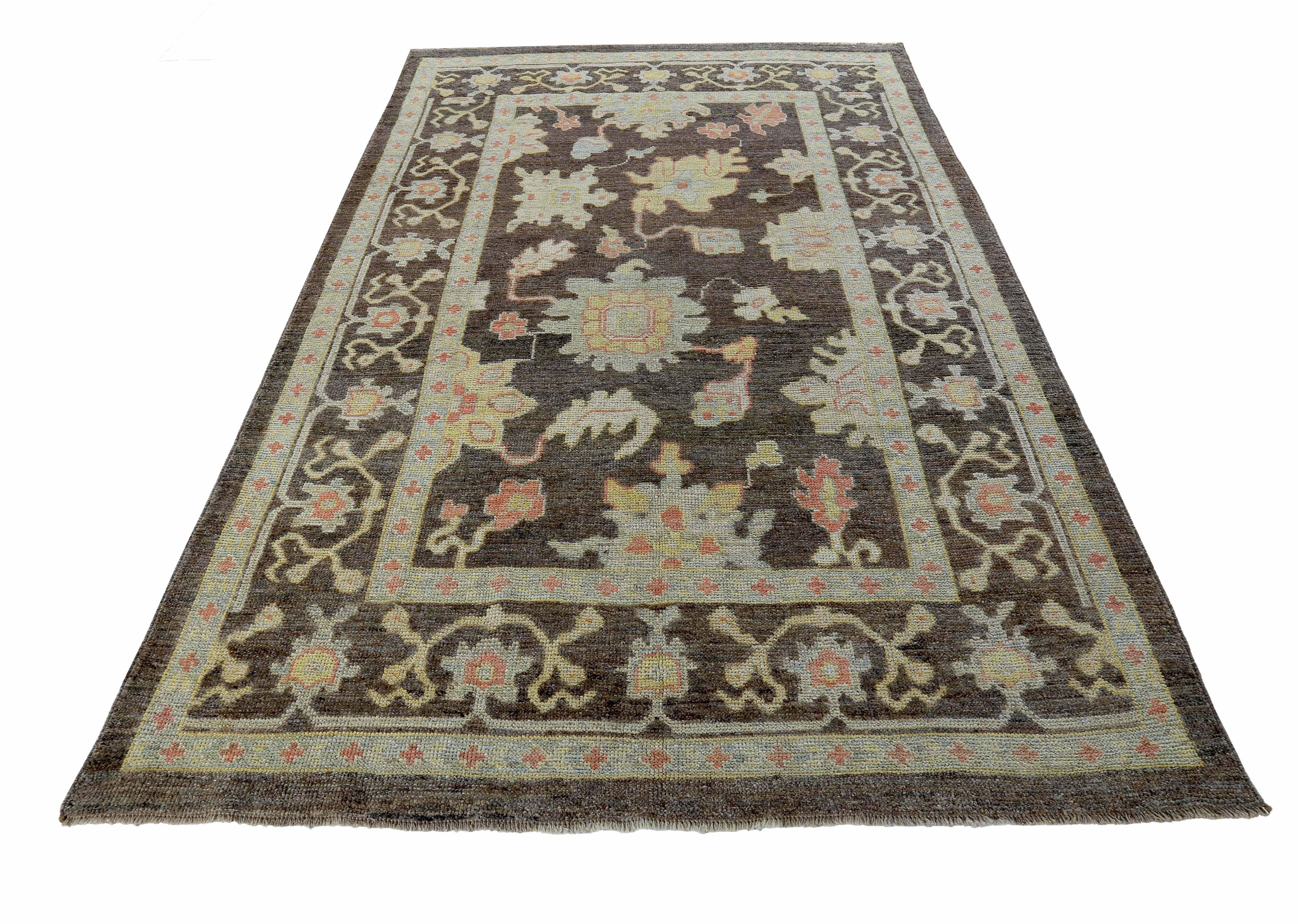 New Turkish rug made of handwoven sheep’s wool of the finest quality. It’s colored with organic vegetable dyes that are certified safe for humans and pets alike. It features pink and blue floral details on an elegant brown field. Flower patterns are