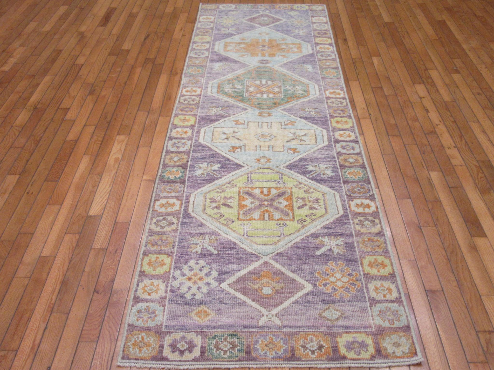 This is a new hand knotted runner rug from Turkey. It is made with durable Turkish wool in traditional geometric multi medallion Anatolian design. It has the rich updated joyful colors bringing life to any spot or hall. It measures 2' 11'' x 9' 2''