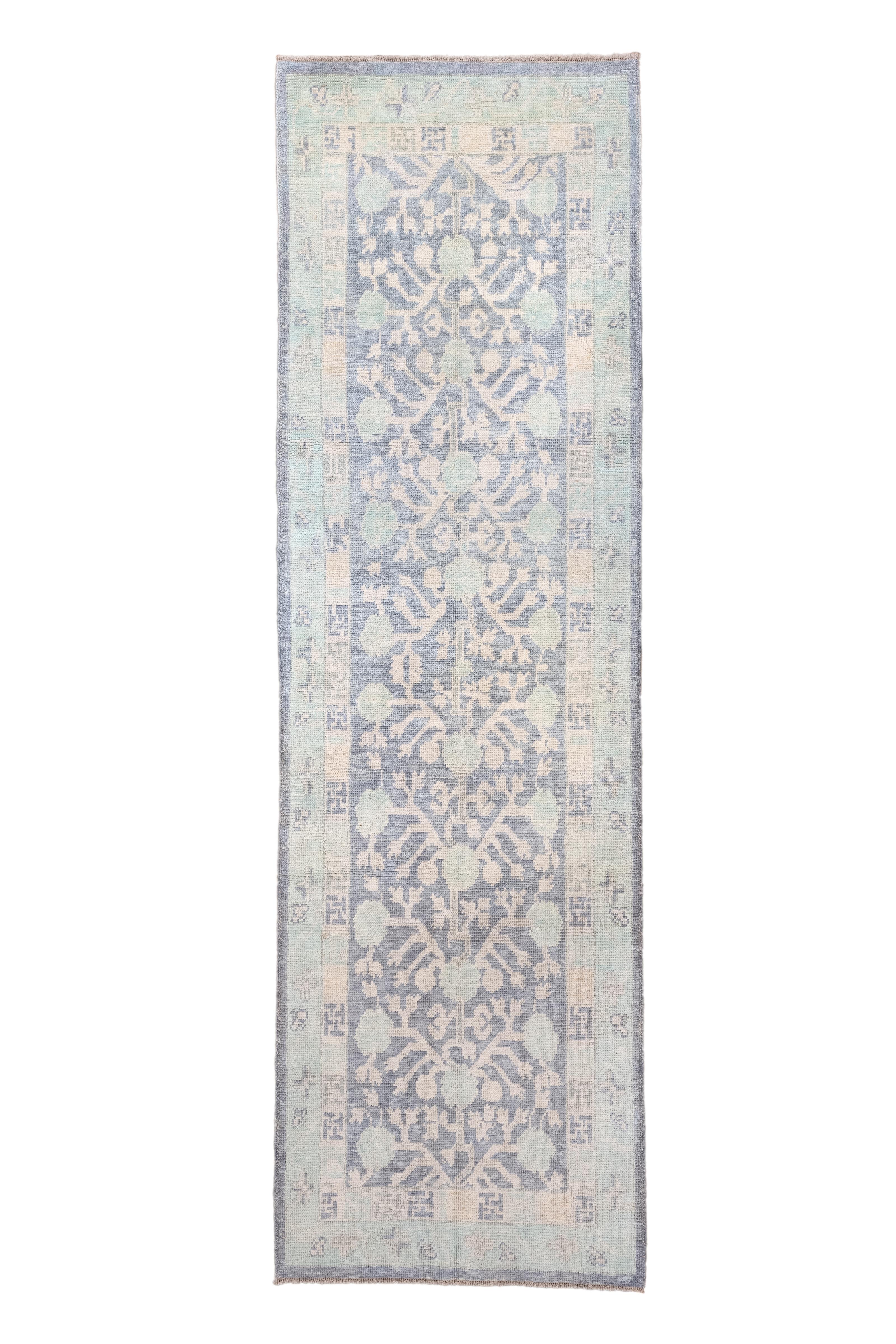 This unusual Anatolian kenare (runner) shows a west Turkestan Khotan design of ascending pomegranate branches and round fruit, on an abrashed slate ground. On wool, moderate weave. As new condition with slightly pre-worn pile for that antique