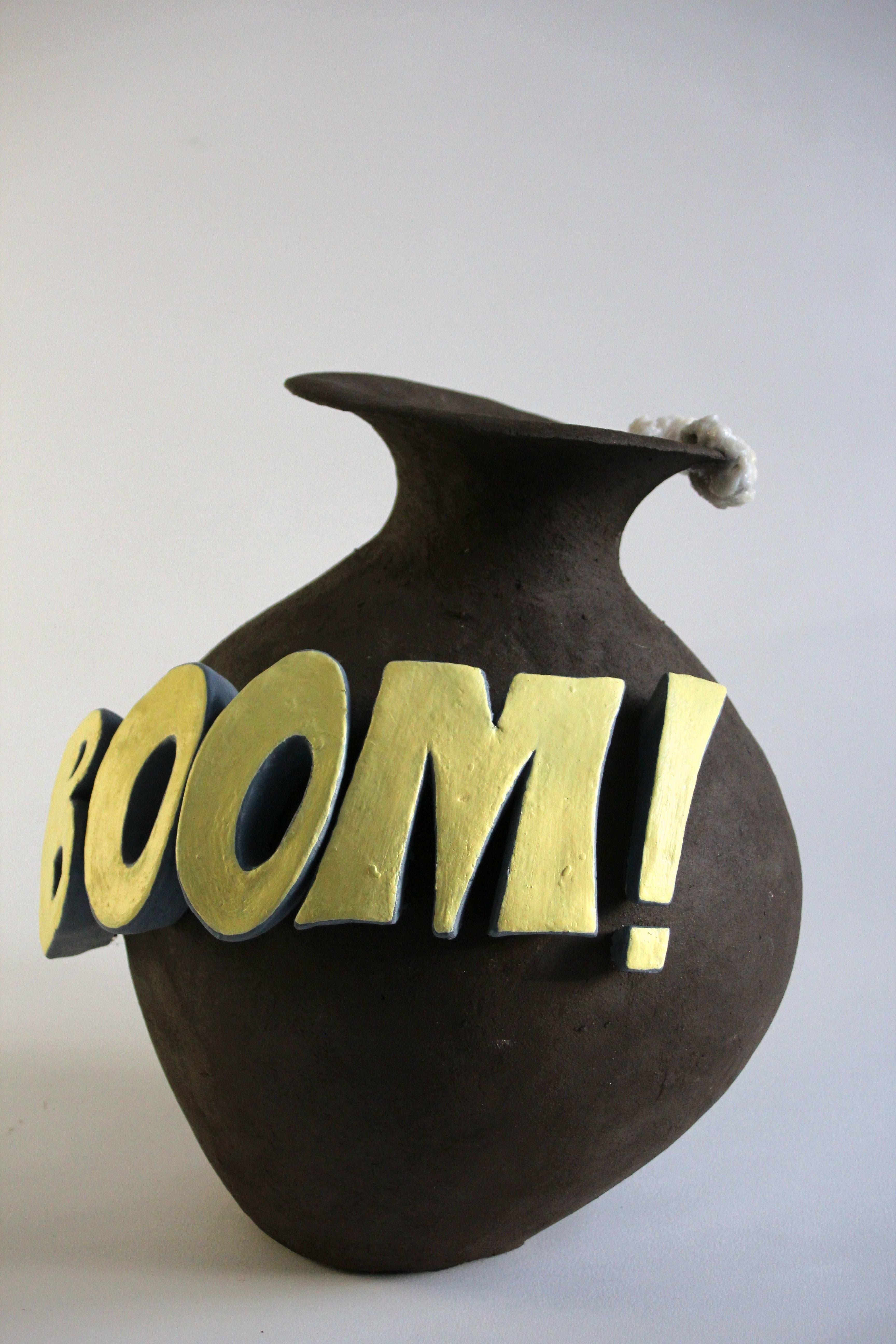 Boom!
Ceramic vase design object. This is one-of-a-kind product and hand built ceramic. On the side of this vessel is cartoon styled fonts with word Boom!
Letters are made of clay and painted after vase is burned in ceramic kiln. 
On the edge is
