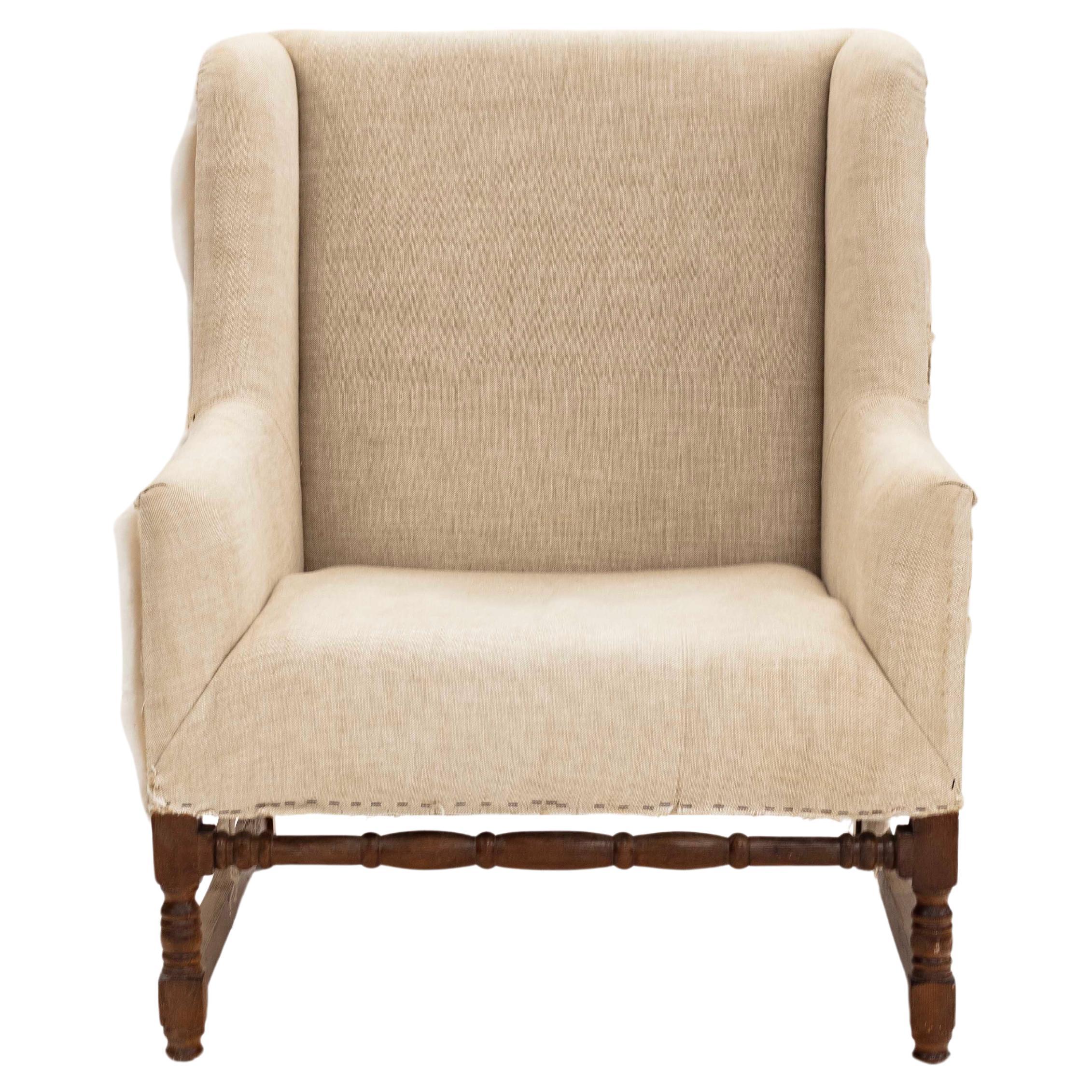 Introducing a dynamic seating set that combines elegance with comfort, featuring a large wing chair accompanied by a matching ottoman. This set is new and ready to be upholstered in the fabric and color of your choice. The stained mahogany wood base