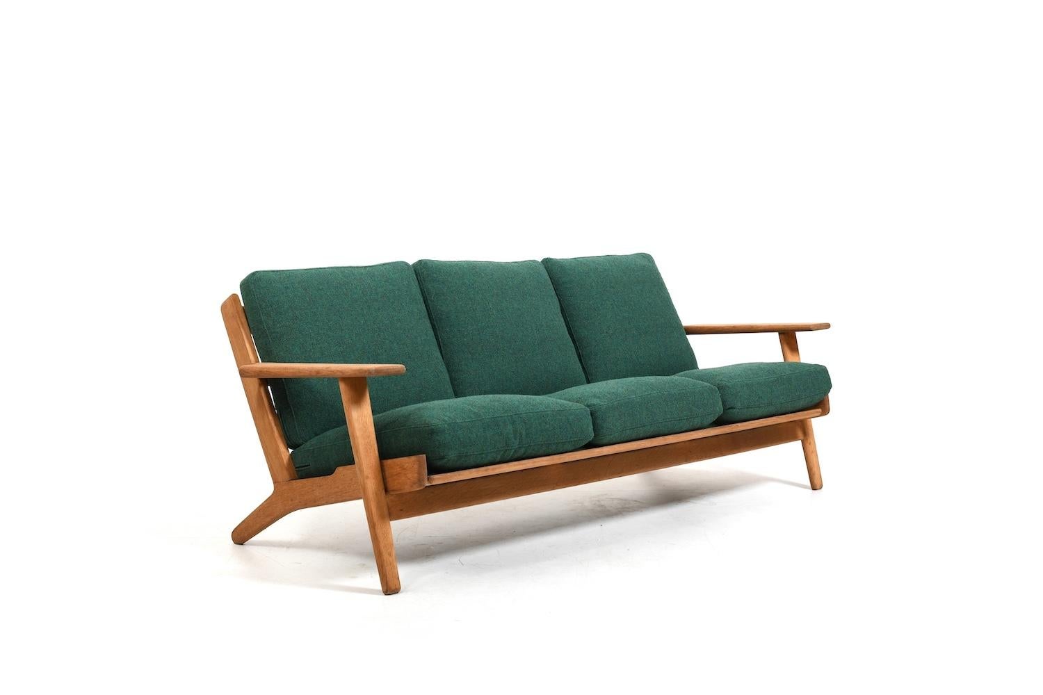 GE-290 / 3 sofa by Hans J. Wegner for Getama Denmark 1950s. Made in solid oak. New cushions with green fabric from Kvadrat and new stripes.. Sofa prod. 1950s. During the restoration, the later white Tripp Trapp color was removed. Occasionally still