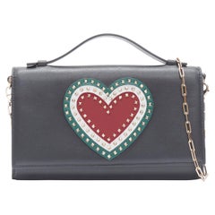 VALENTINO Pochette à chaîne en cuir noir avec cœur rouge et vert à clous dorés, neuve