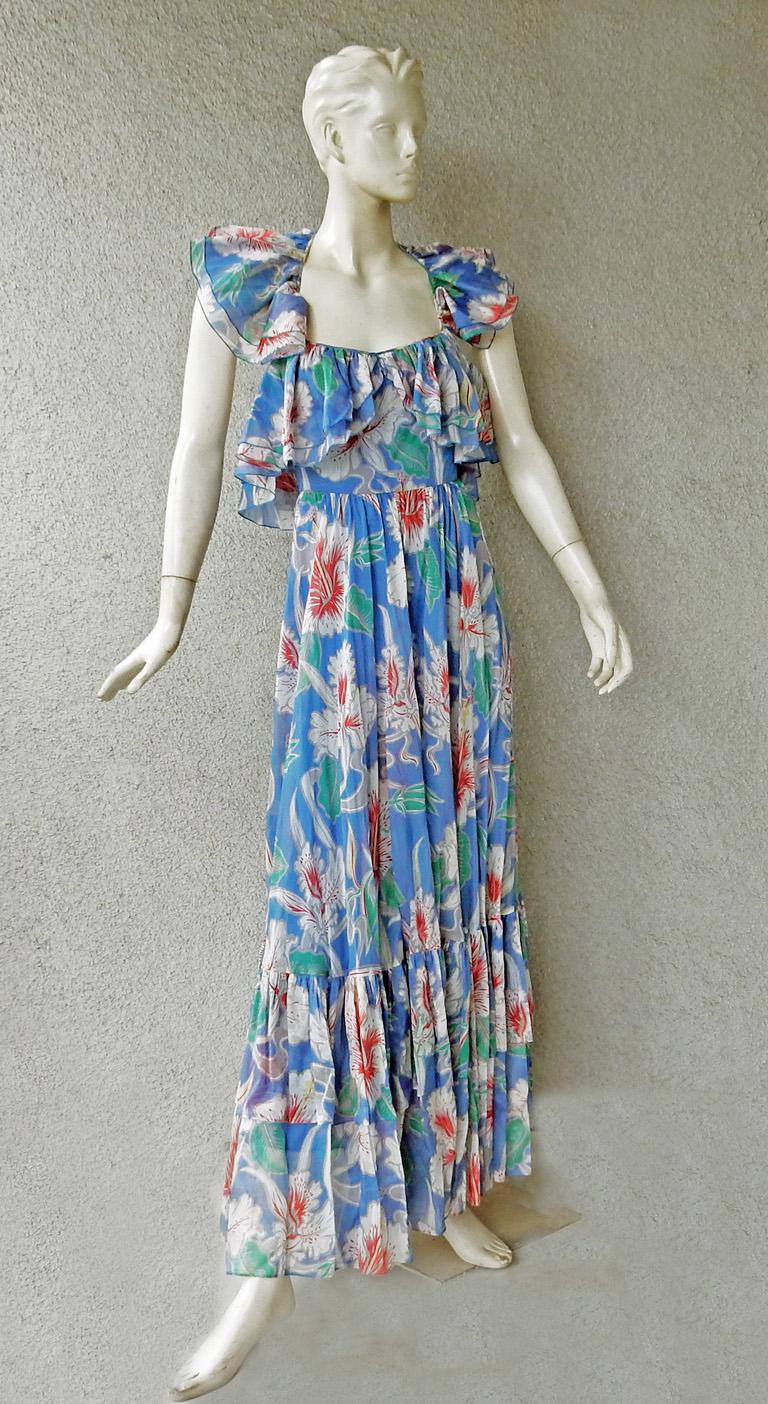 Valentino new halter maxi dress in a delightful colorful floral pattern.  Ruffle halter encircles shoulders featuring open back ruffle treatment. Waist fits semi close to body and extends into a full skirt with double ruffle tiers at hemline.  Full