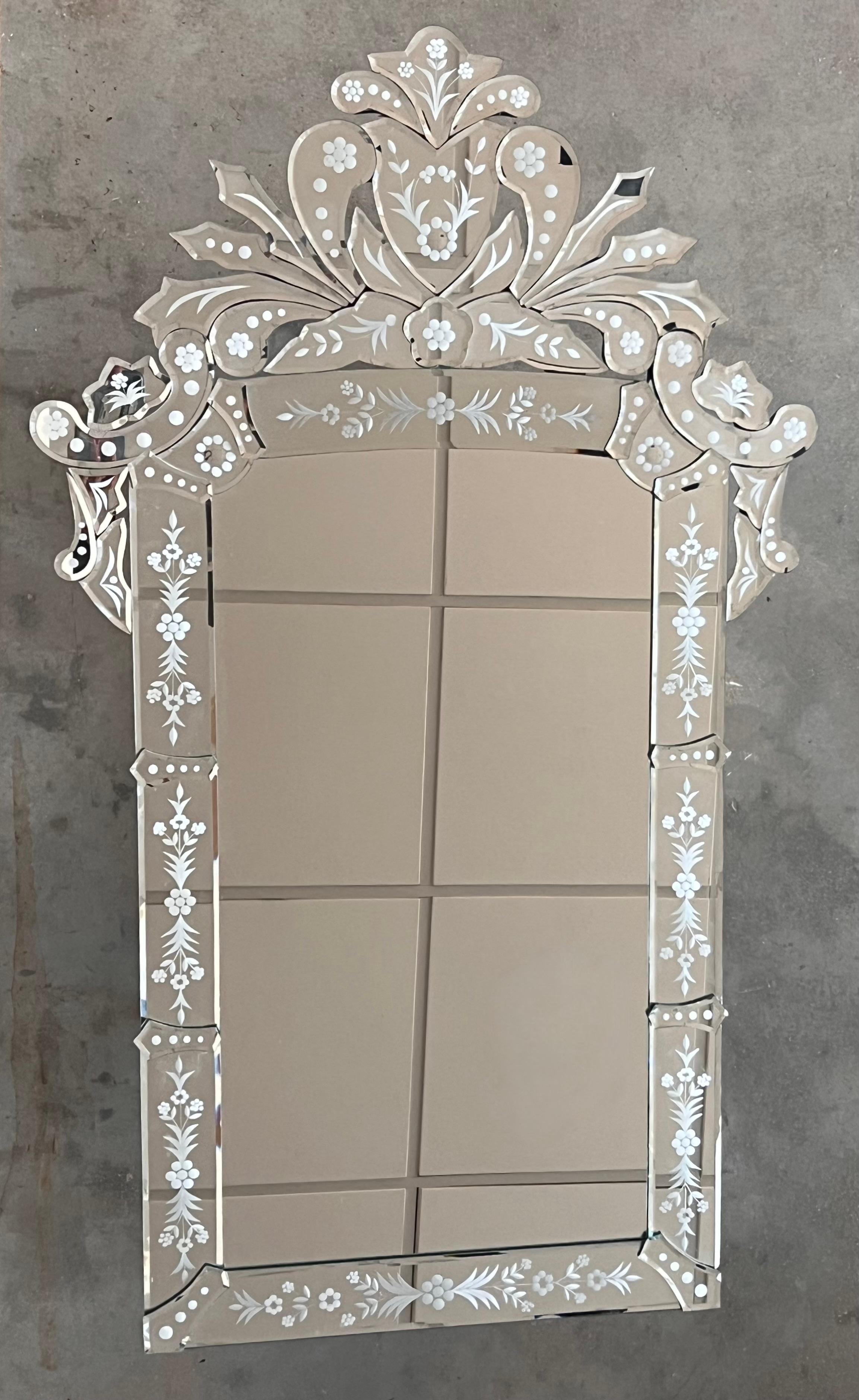 Miroir vénitien en verre à bordure façonnée et gravée, surmonté de crêtes naturalistes gravées en miroir.