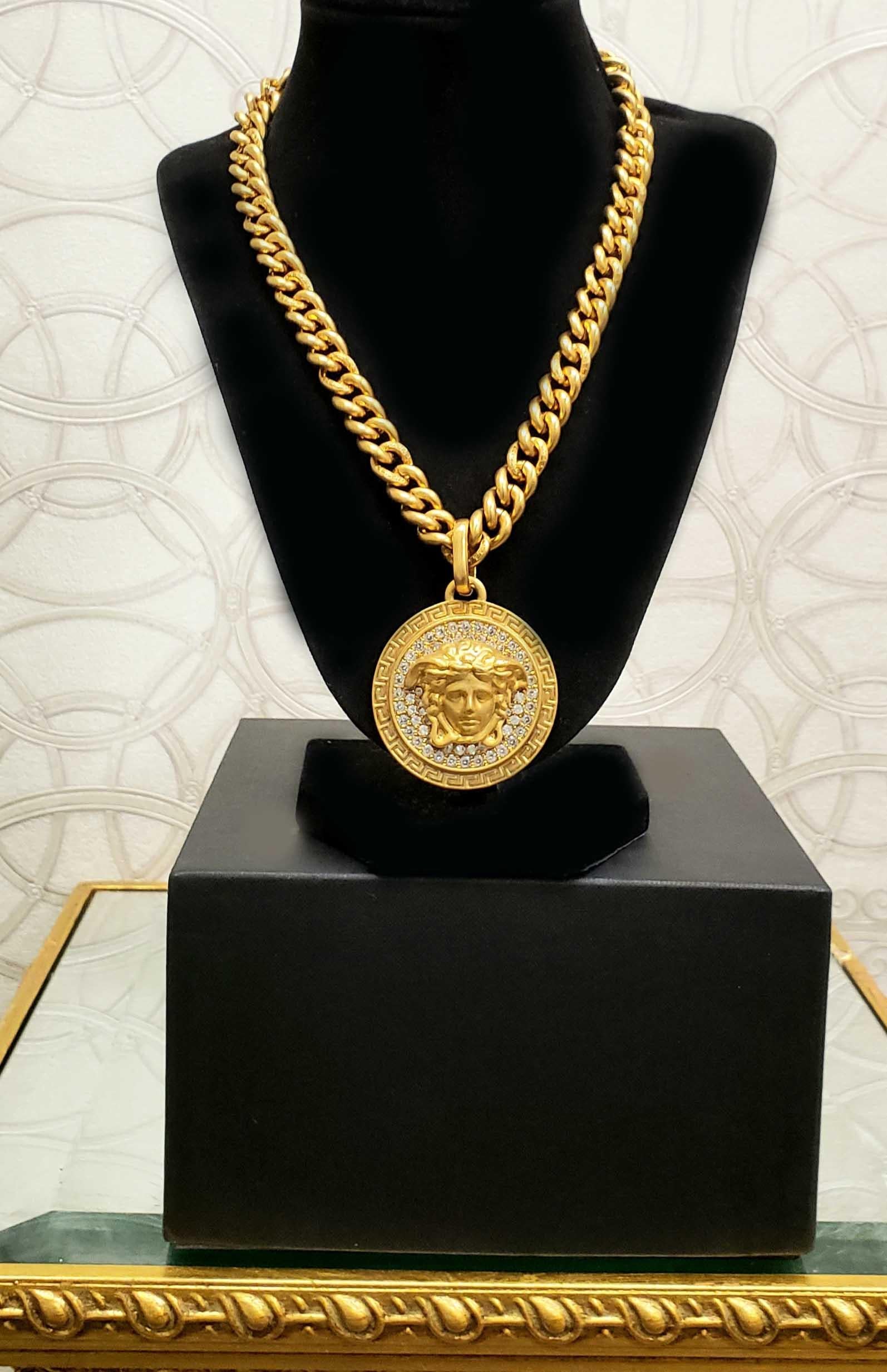 VERSACE

Brushed 24CT gold plated necklace.

Crystal embellished medallion with iconic Medusa. 

Logo engraved clasp fastening.

Made in Italy

Brand New, display model got minor scratches.

Comes with Versace box and authenticity card.
