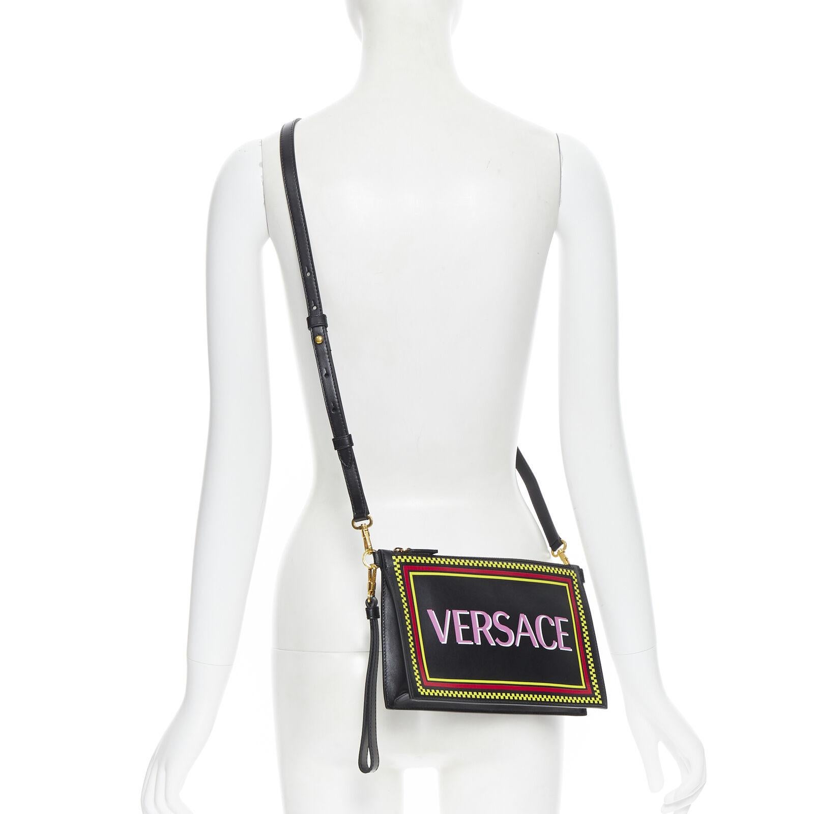 new VERSACE 90s graphic logo black calf zip pouch crossbody clutch bag
Reference: TGAS/B00507
Brand: Versace
Designer: Donatella Versace
Model: 90's logo top zip crossbody pouch
Collection: Vintage Logo 
Material: Leather
Color: Black
Pattern: