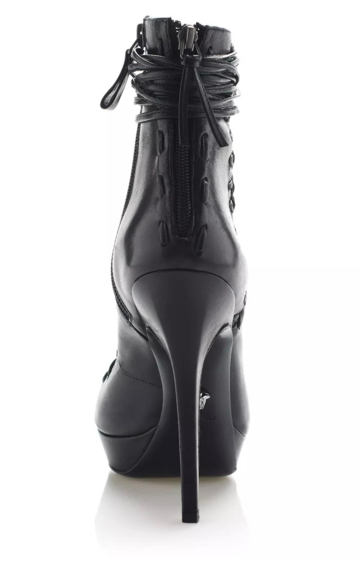 VERSACE 
ZAPATOS DE CORDONES DE CUERO NEGRO.
Este botín Versace con puntera afilada y cordones presenta un detalle de costuras a la vista en la cremallera trasera.
Cremallera lateral 
Plantilla de piel 
Suela de cuero 
100% cuero 
El tacón cubierto