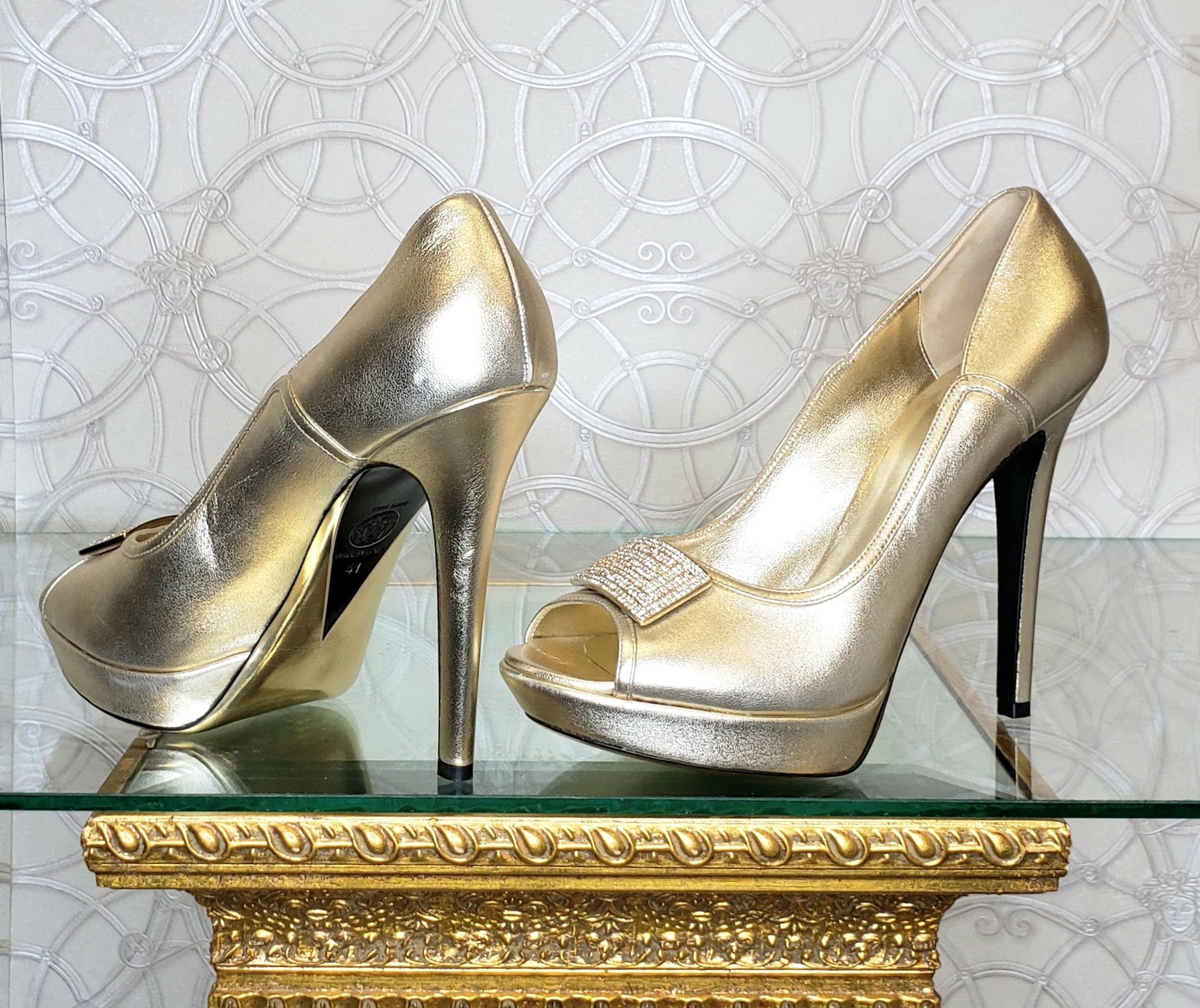 VERSACE 

Mit einem kristallbesetzten Greek Key-Logo versehen, 

Die goldenen Lederpumps von Versace stehen ganz oben auf dem Wunschzettel jeder Fashionista. 

Ergänzen Sie den luxuriösen Farbton mit reichen Juwelentönen, um einen glamourösen