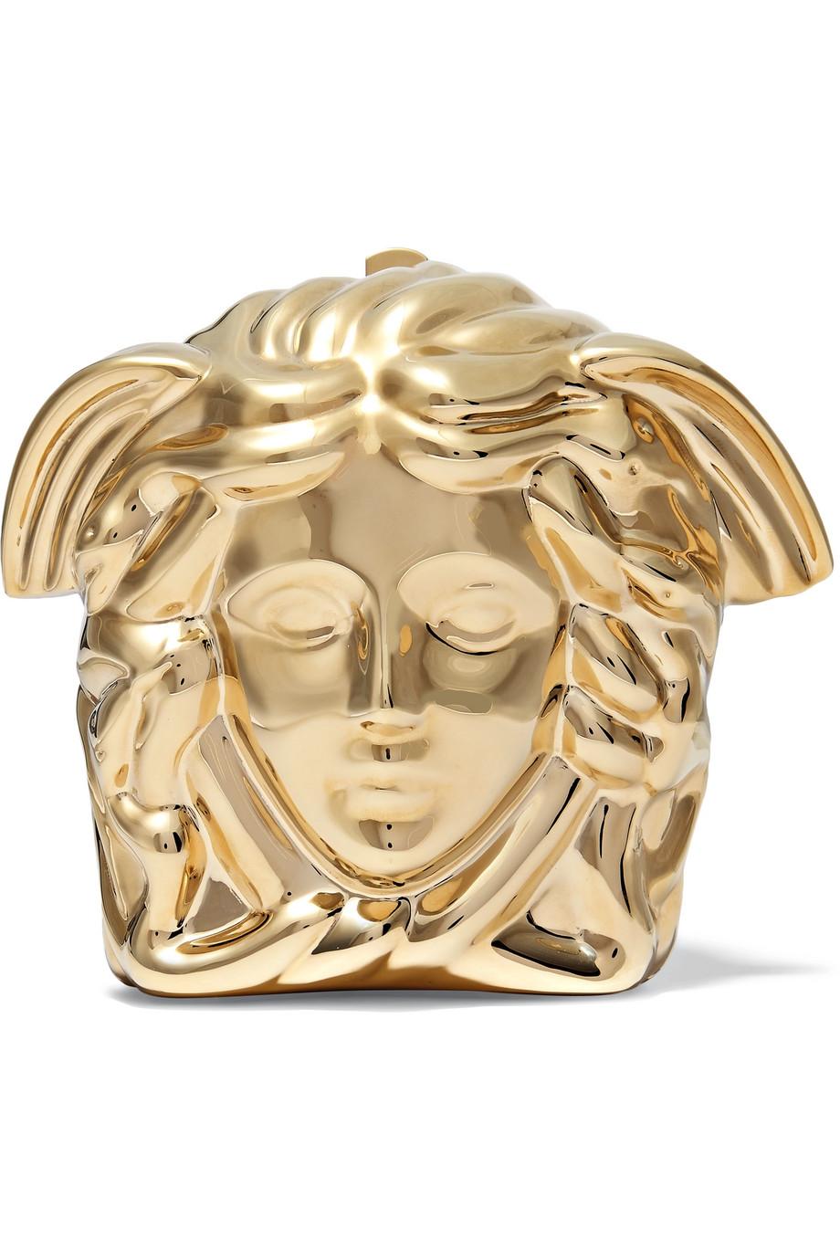 Versace clutch is expertly molded from gleaming gold-tone metal in the shape of the Medusa head - a brand signature since 1978. Handcrafted in Italy, this miniature style has a detachable chain shoulder strap and is lined in smooth black suede.