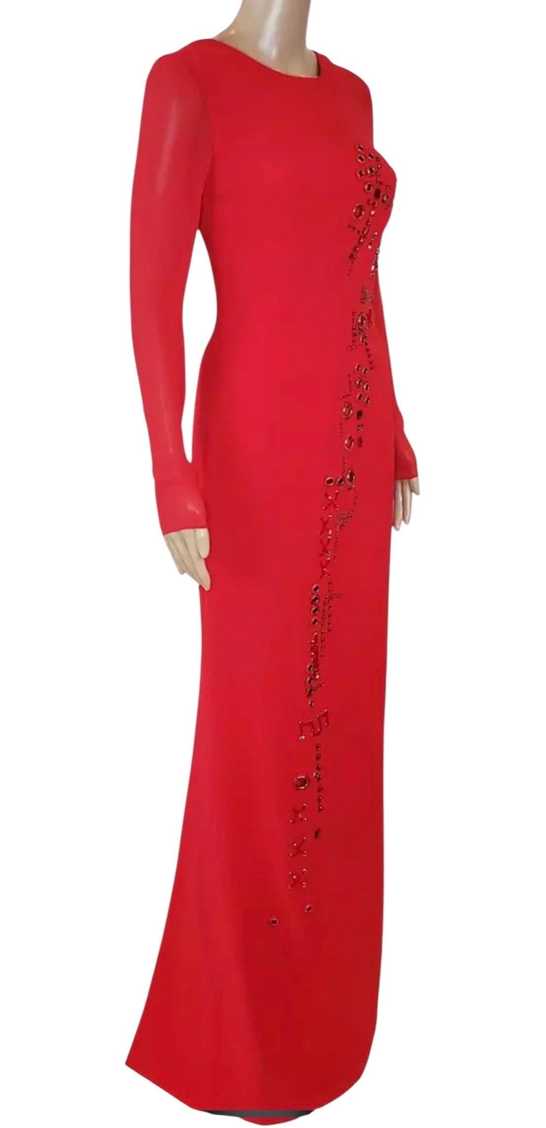 VERSACE
Das Kleid von Versace ist aus 100 % Seide gefertigt und mit Verzierungen versehen. 
Dieses rote Kleidungsstück hat eine schmale Silhouette und lange Ärmel aus transparentem Chiffon und ist vollständig gefüttert.
Inhalt: 100% Seide
Futter: