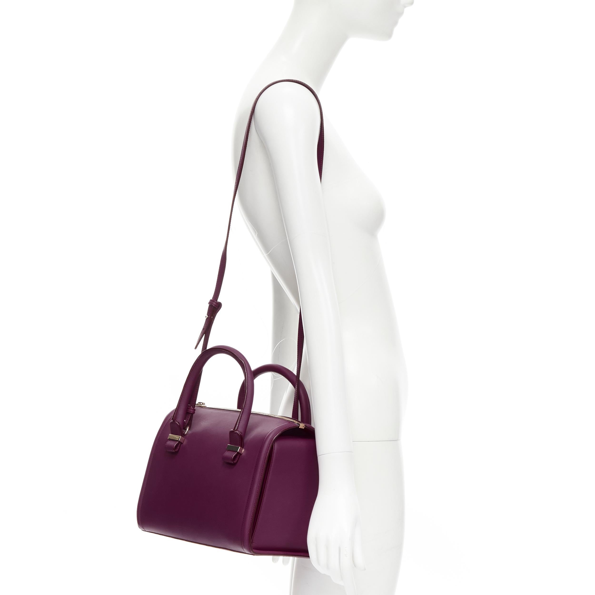 new VICTORIA BECKHAM Seven purple leather rolled handle structured bowling bag 
Reference: MELK/A00190 
Brand: Victoria Beckham 
Model: Seven bowling bag 
Material: Leather 
Color: Purple 
Pattern: Solid 
Closure: Zip 
Extra Detail: Gold-tone