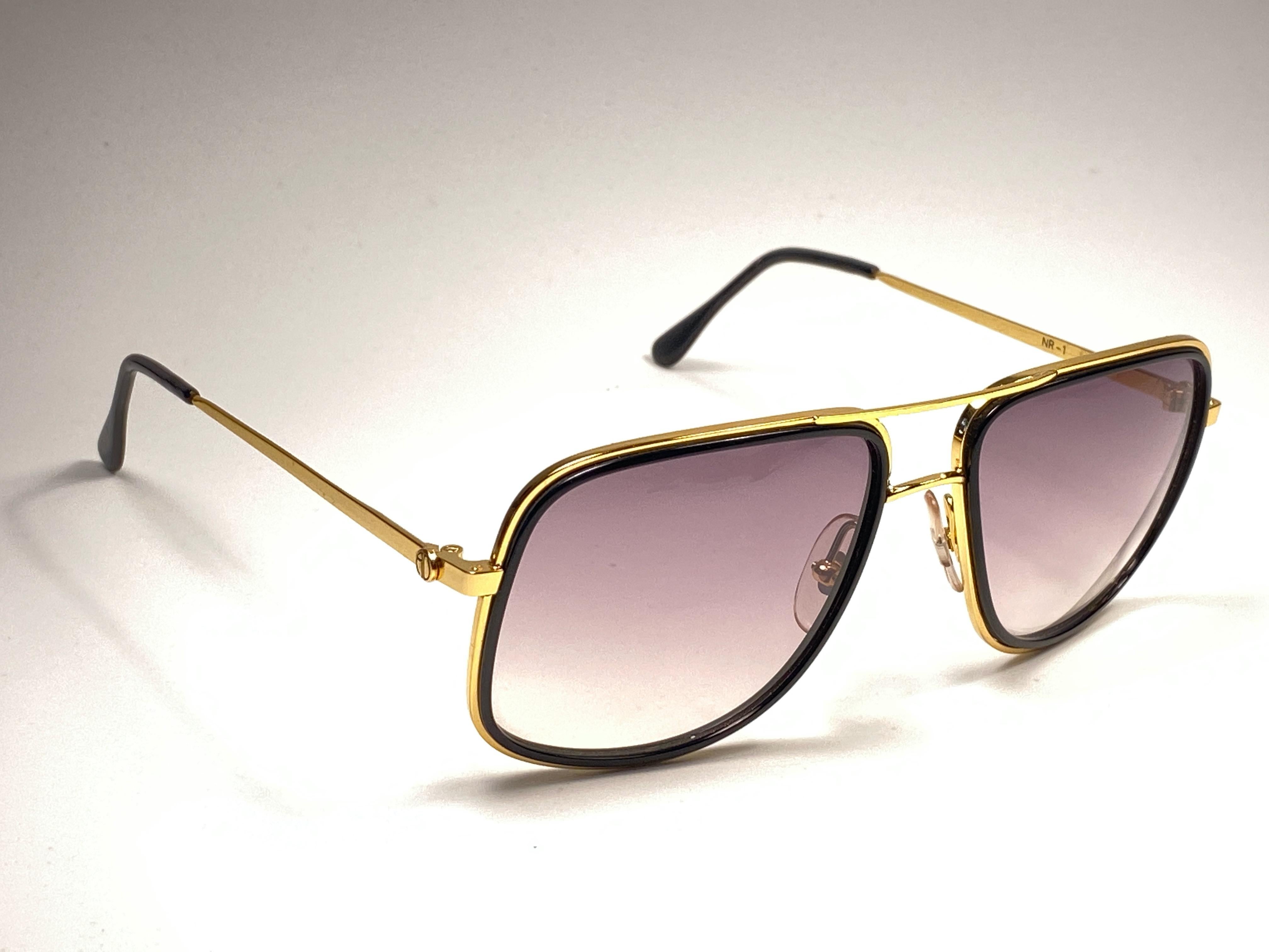 New vintage Alain Delon sunglasses.

Oversized gold with black details frame holding a pair of spotless brown gradient lenses.   

New, never worn or displayed. 

 Made in Italy.

MEASUREMENTS 



FRONT : 14 CMS

LENS HEIGHT : 4.5 CMS

LENS WIDTH :