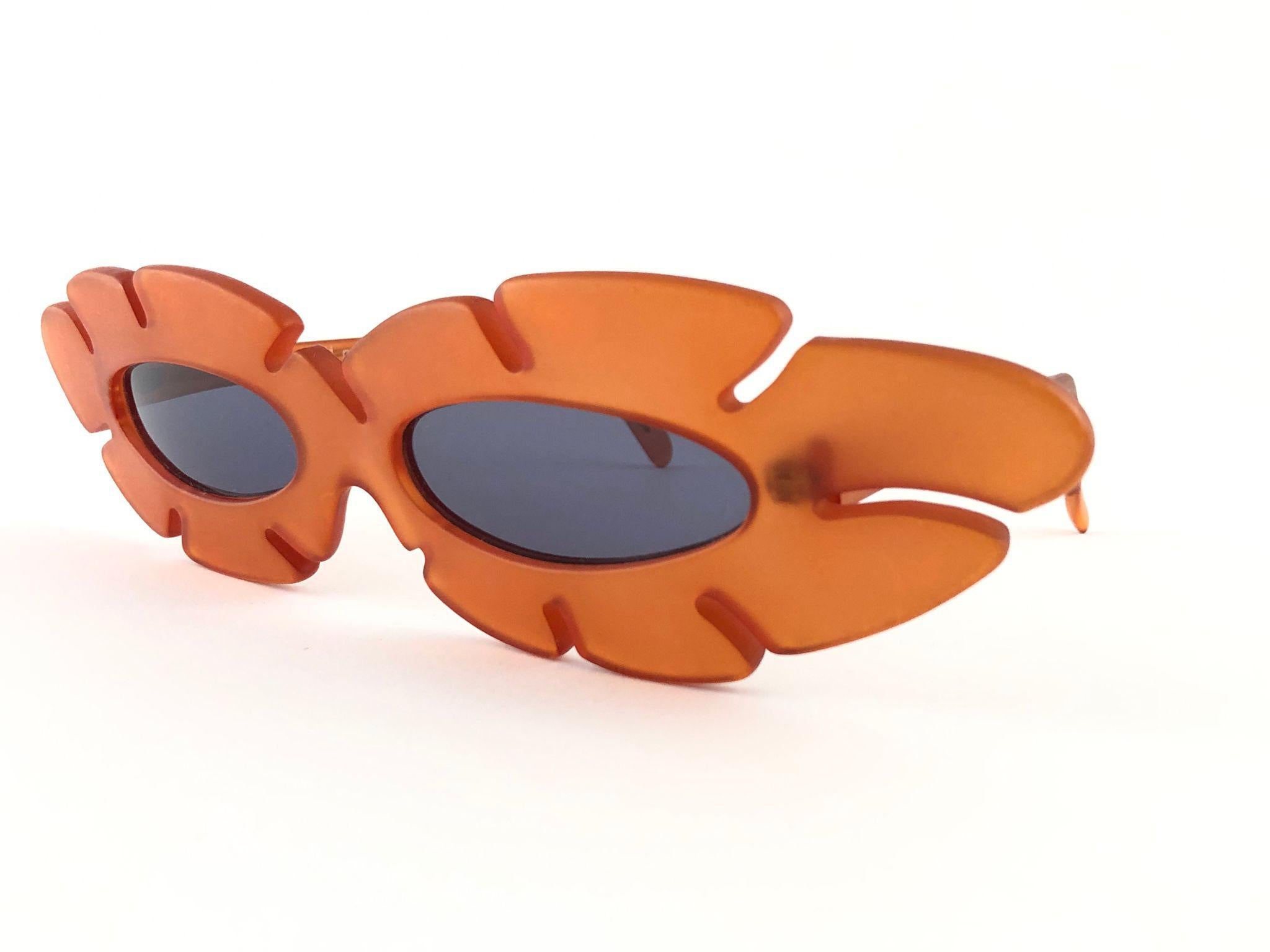 New Vintage Alain Mikli ultra wide translucent tangerine frame.

Rare item in new and unworn condition. Spotless grey lenses.

Please consider that this item is nearly 40 years old so it could show minor sign of wear due to storage.

Made in