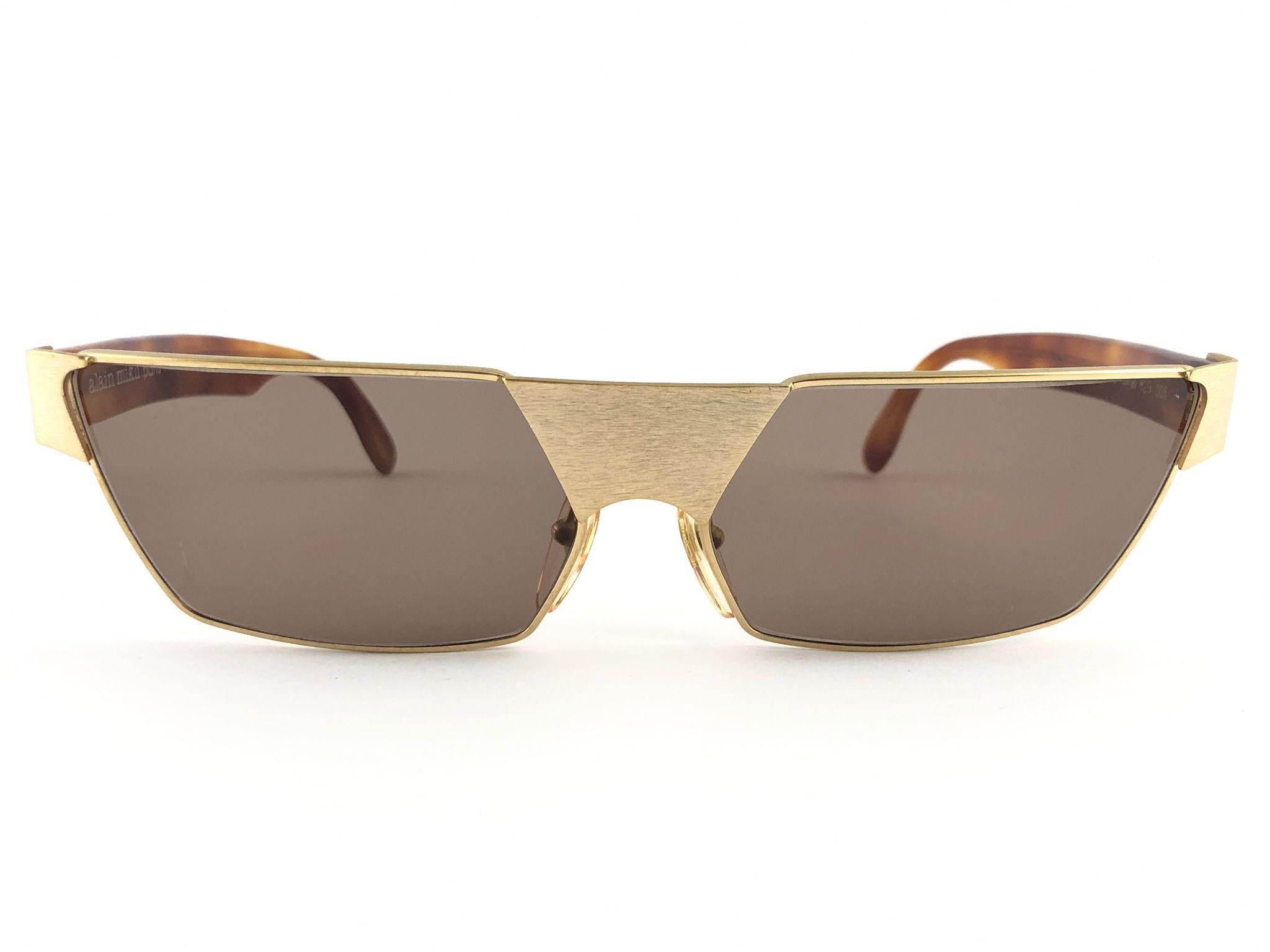 New Vintage Alain Mikli gold & tortoise with medium brown lenses frame.

Rare item in new and unworn condition. 

Please consider that this item is nearly 40 years old so it could show minor sign of wear due to storage.

Made in