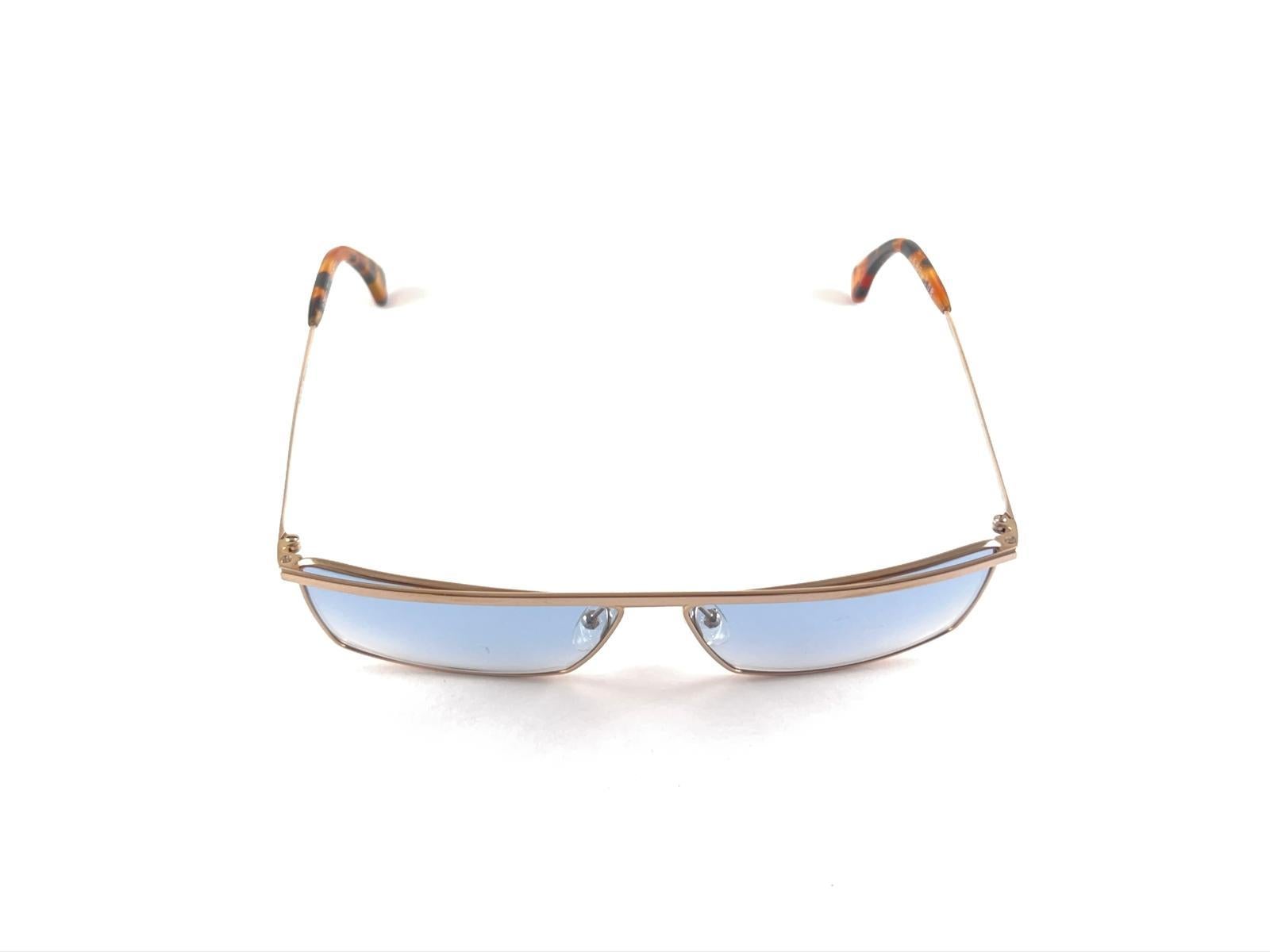 
New Vintage Alain Mikli Rectangular Gold Frame Holding A Pair Of Light Gradient Blue Lentes Sunglasses
Rare Item In New And Unworn Condition. 
Please Consider That This Item Is Nearly 40 Years Old So It Could Show Minor Sign Of Wear Due To