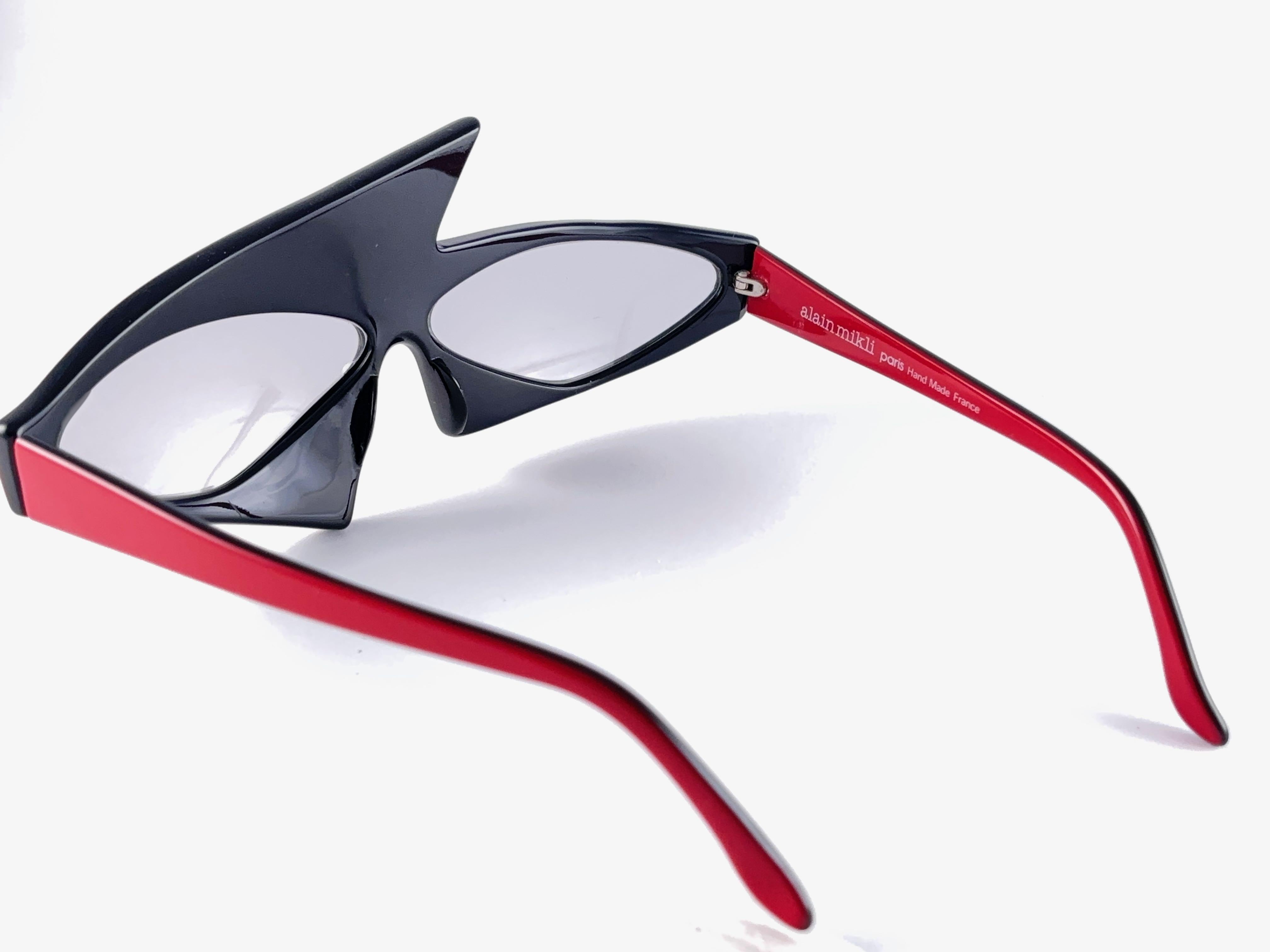 New 1980'S Alain Mikli Sonnenbrille. Avantgarde Schwarz und Rot Assimetrischer Rahmen, der hellgraue Gläser trägt. Dasselbe Modell von Helmut Newton für die Vogue im Jahr 1983.

 

Neu, nie getragen oder ausgestellt. Dieser Artikel Kleinere anzeigen