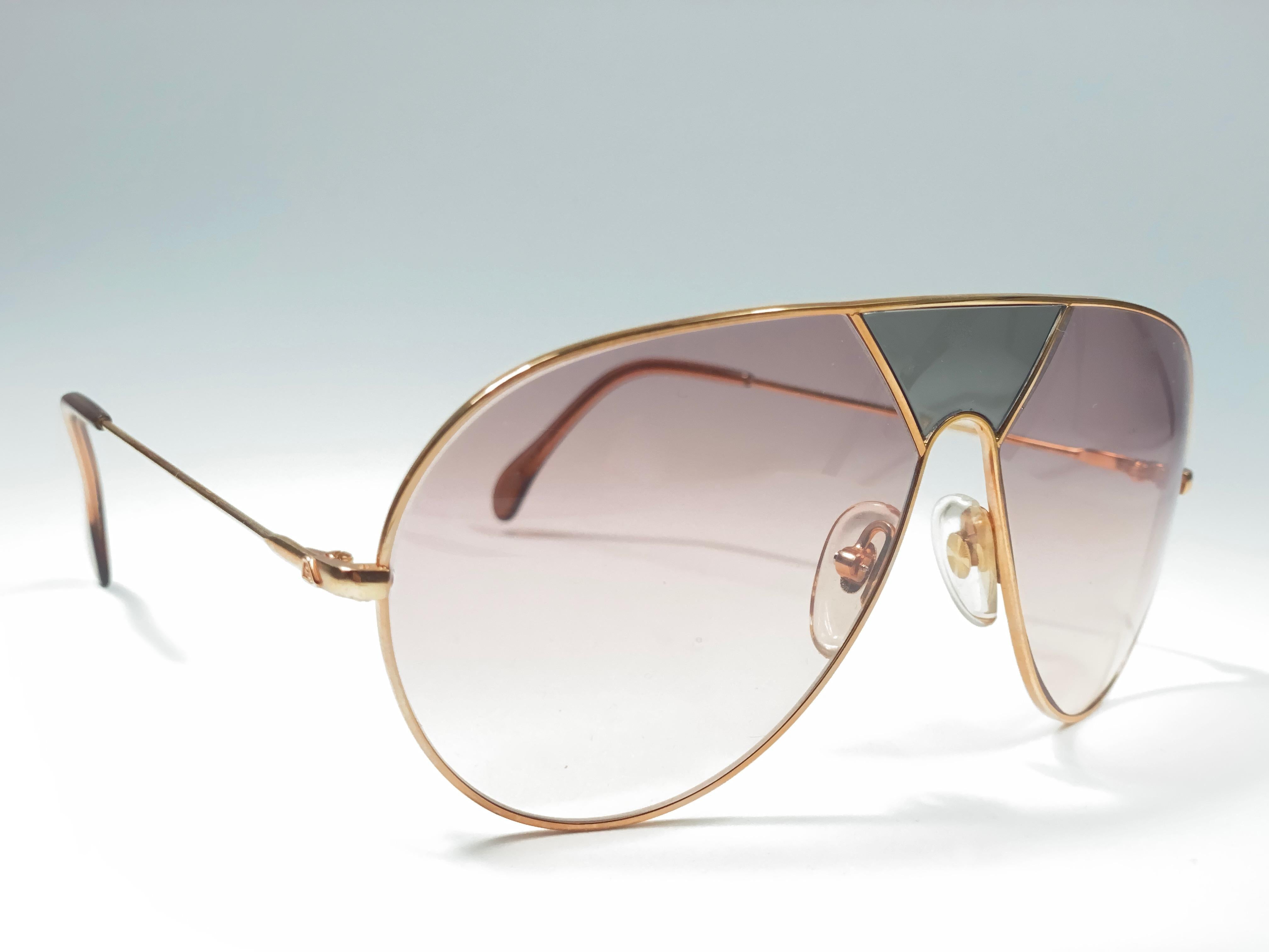 New Vintage Alpina TR3 Aviator Sunglasses. Gold frame with green insert and candy pink lenses.
This pair has a minor sign of wear due to storage.
Made in West Germany.