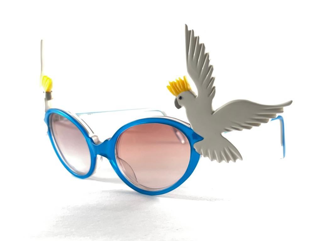Eine Sonnenbrille mit hohem Sammlerwert, signiert von English Anglo American Optical.

New Vintage Anglo American Eyewear Kakadus akzentuiert blau  Rahmen Sonnenbrille mit Medium Rose Linsen 1970'S Handmade. 

Dieser Artikel kann aufgrund der