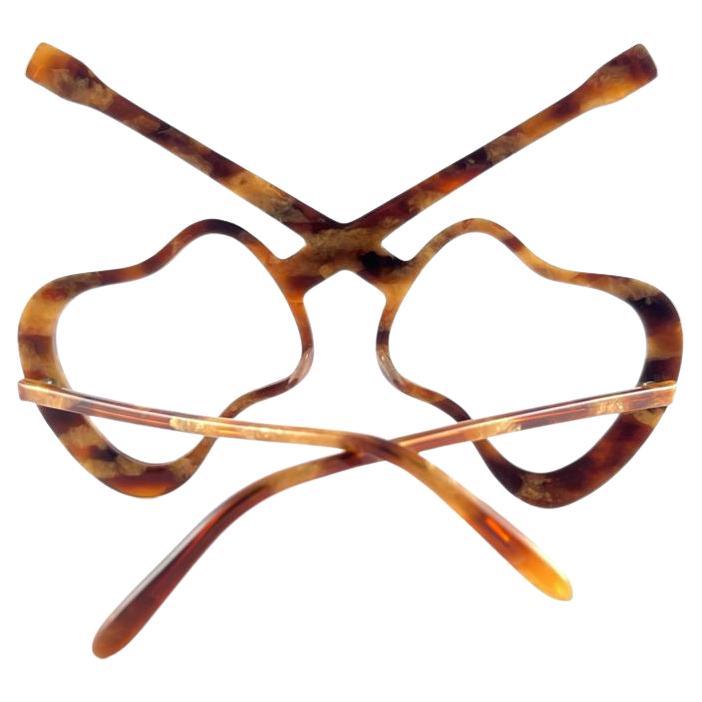 Eine Sonnenbrille mit hohem Sammlerwert, signiert von English Anglo American Optical.

New Vintage Anglo American Eyewear Schildpatt in Form von zwei Gitarren Rahmen 1970'S Handmade. 

Dieser Artikel kann aufgrund der Lagerung geringfügige