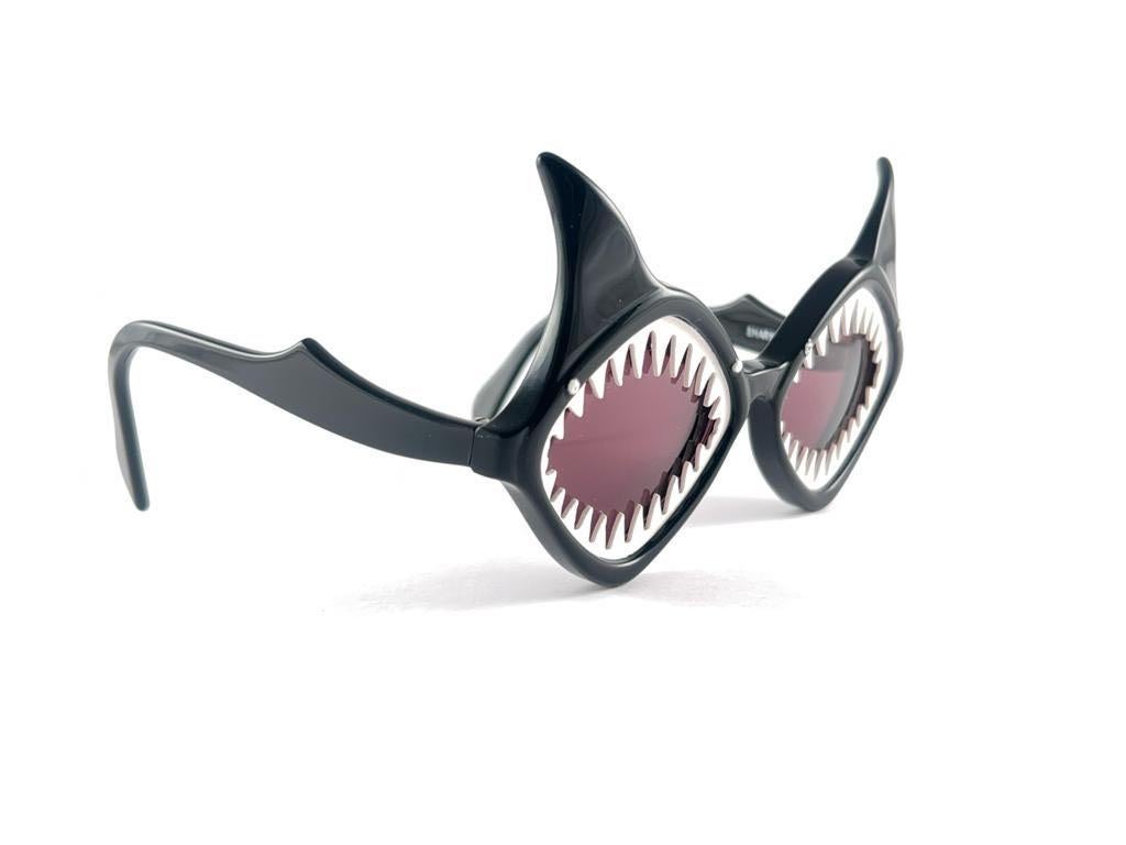 Eine Sonnenbrille mit hohem Sammlerwert, signiert von English Anglo American Optical.

New Vintage Anglo American Eyewear schwarz in Form von zwei mächtigen Haien akzentuiert Rahmen 1970'S Handmade. 

Dieser Artikel kann aufgrund der Lagerung