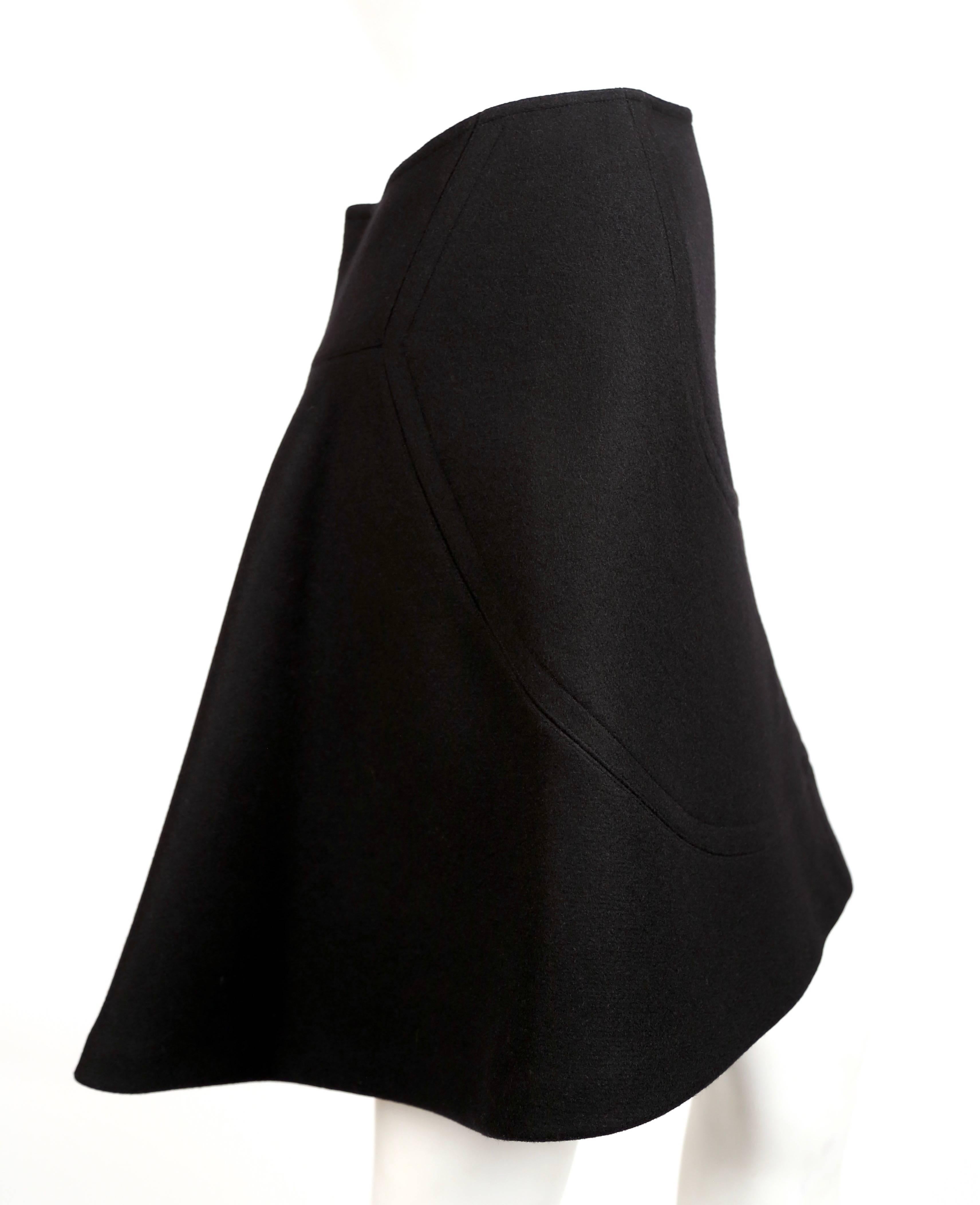 Jet black wool A-line skirt with top-stitching from Azzedine Alaia dating to fall of 2008 as seen on the Alaia runway. French size 40 although this runs very small. Approximate measurements: waist from side to side (curved cut) is about 26