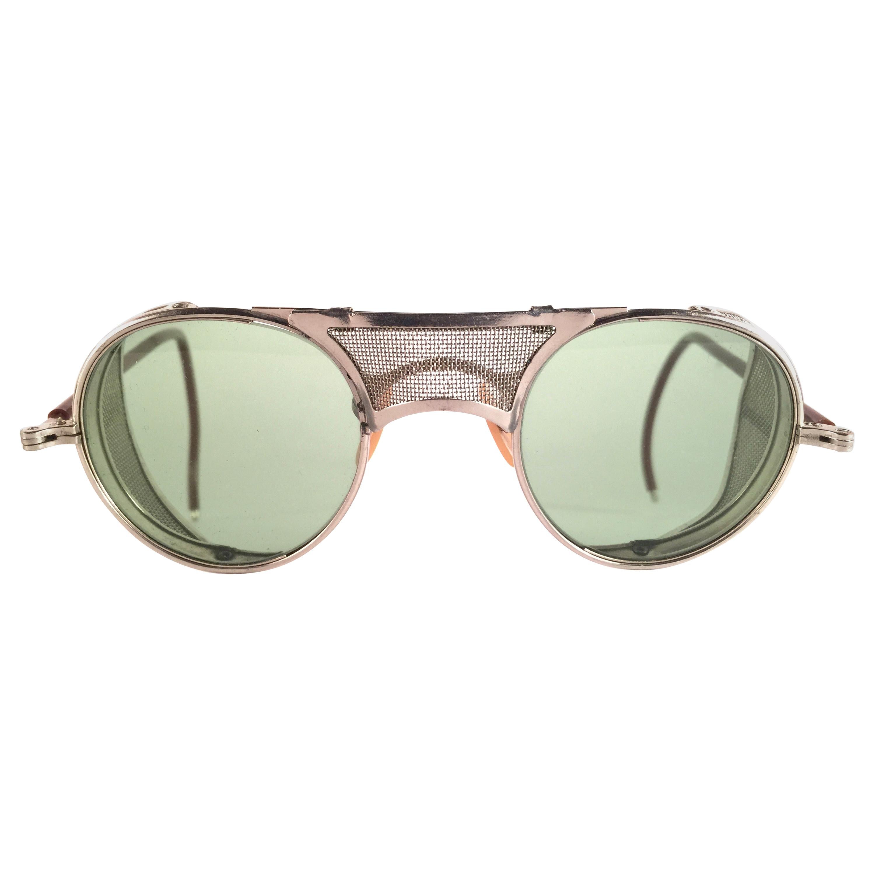 Superb Item!  
1950's Bausch & Lomb Safety Goggles. Folding silver metal side cups and special wrapped temples. Mint true green round lenses.  
A beautiful piece of sunglasses history.