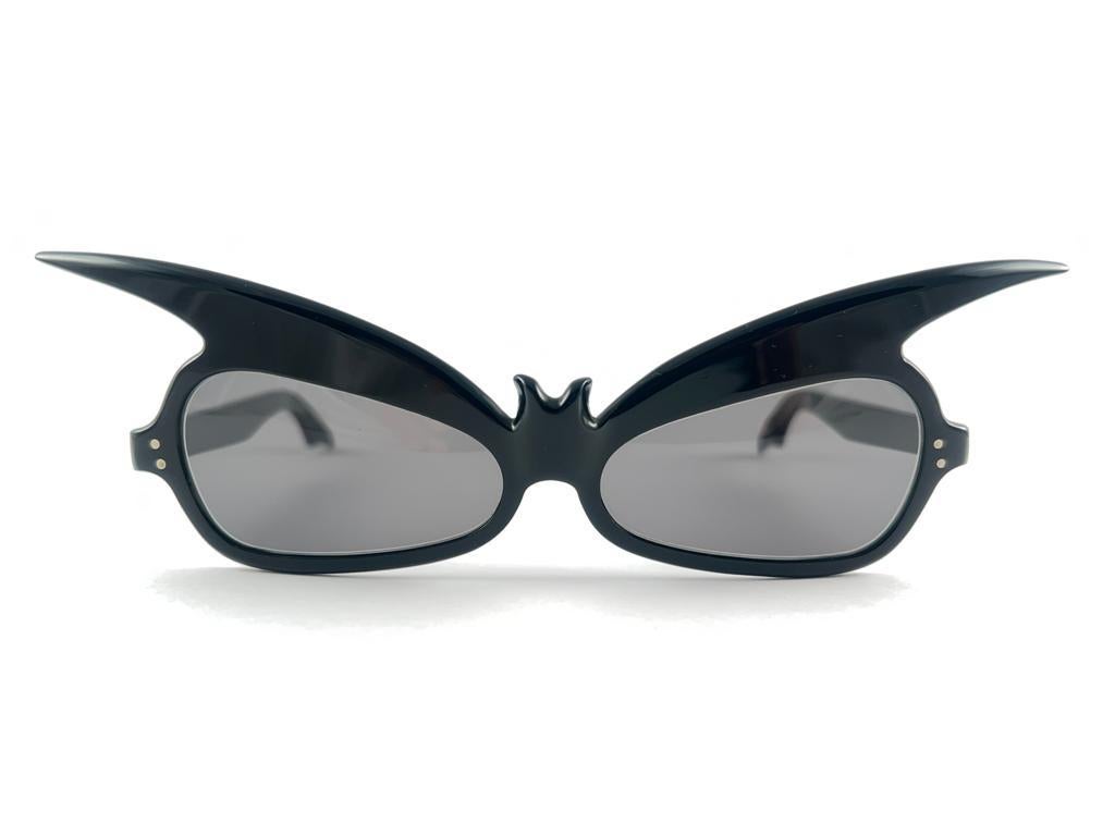 
New, Rare Bat Wings Shape Black Frame Holding A Pair Of Medium Grey Lenses

Please Notice That This Item Is More Than 60 Years Old And Could Show Some Storage Wear. 

New, Ever Worn Or Displayed.



Made In France


Front                           