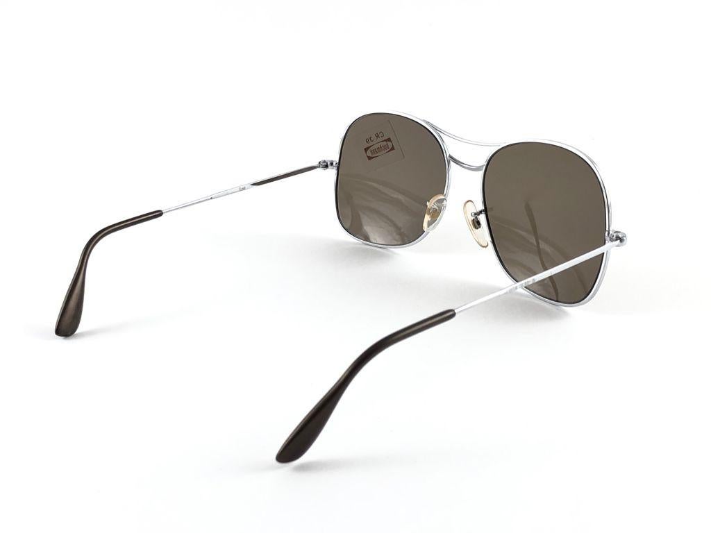 Sunglasses Buchmann L' Ami frame. Made in West Germany 1980's. 

Oversized Metallic silver frame holding a spotless pair of medium brown lenses.

MEASUREMENTS:

Front :                      13.5 cms
Lens Height :            5   cms
Lens Width :     