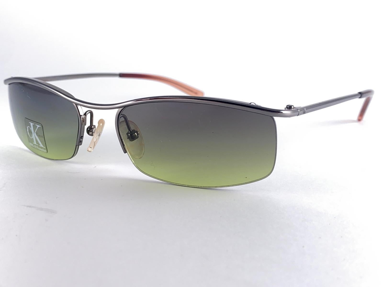 




New Vintage Calvin Klein Y2K 1990'S Wrap Around Small Silver Frame Sunglasses
Green Gradient Lenses.

New, Never Worn Or Displayed.

This Item May Show Minor Sign Of Wear Due To Storage.

Front : 13 Cms
Lens Height : 3  Cms
Lens Width : 5.4