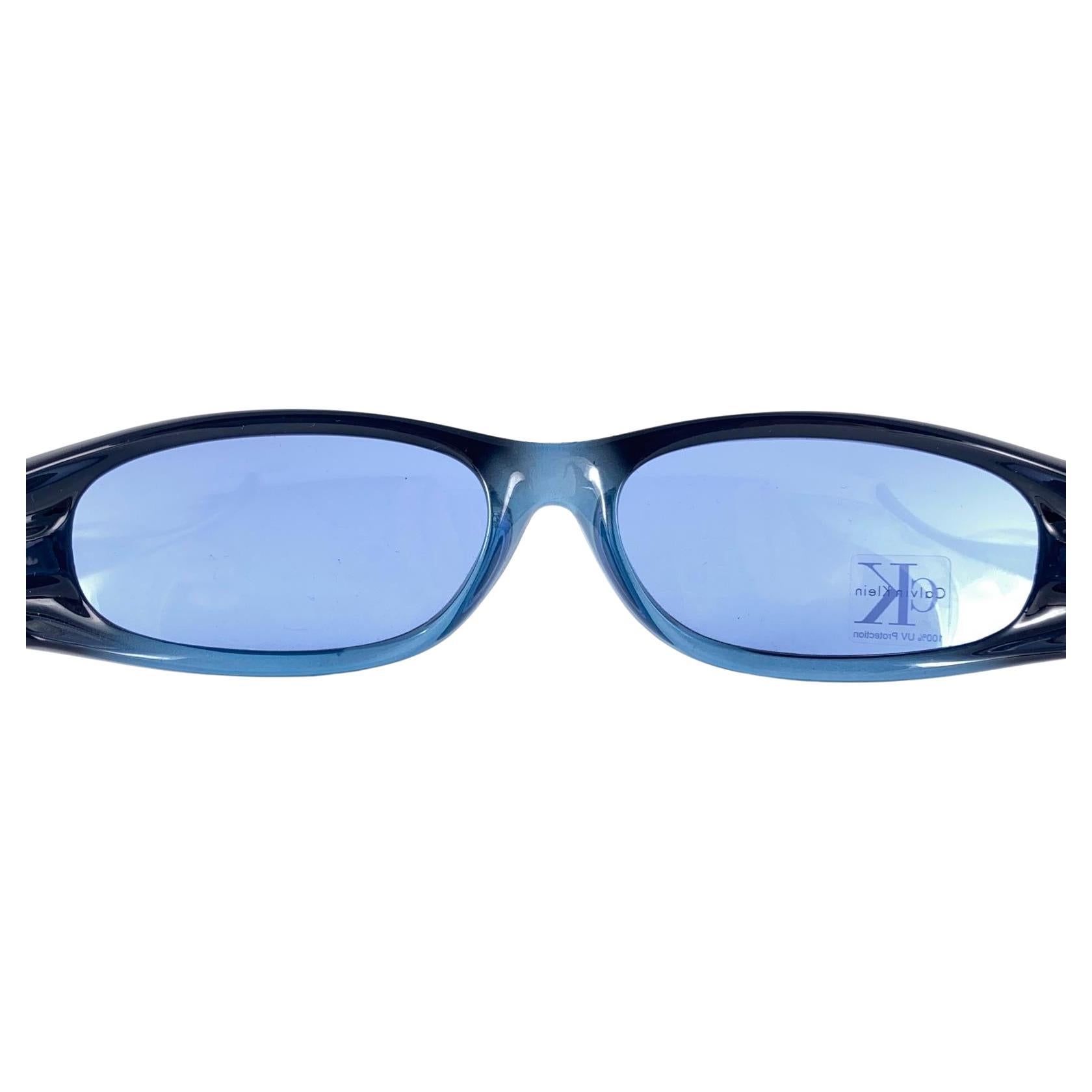 












New Vintage Calvin Klein 1990's Wrap Around Blue Frame Sunglasses Made In German
Lentilles bleues.

Nouveau, jamais porté ni exposé.

Cet article peut présenter des signes mineurs d'usure dus au stockage.

Devant : 18 cm
Hauteur de