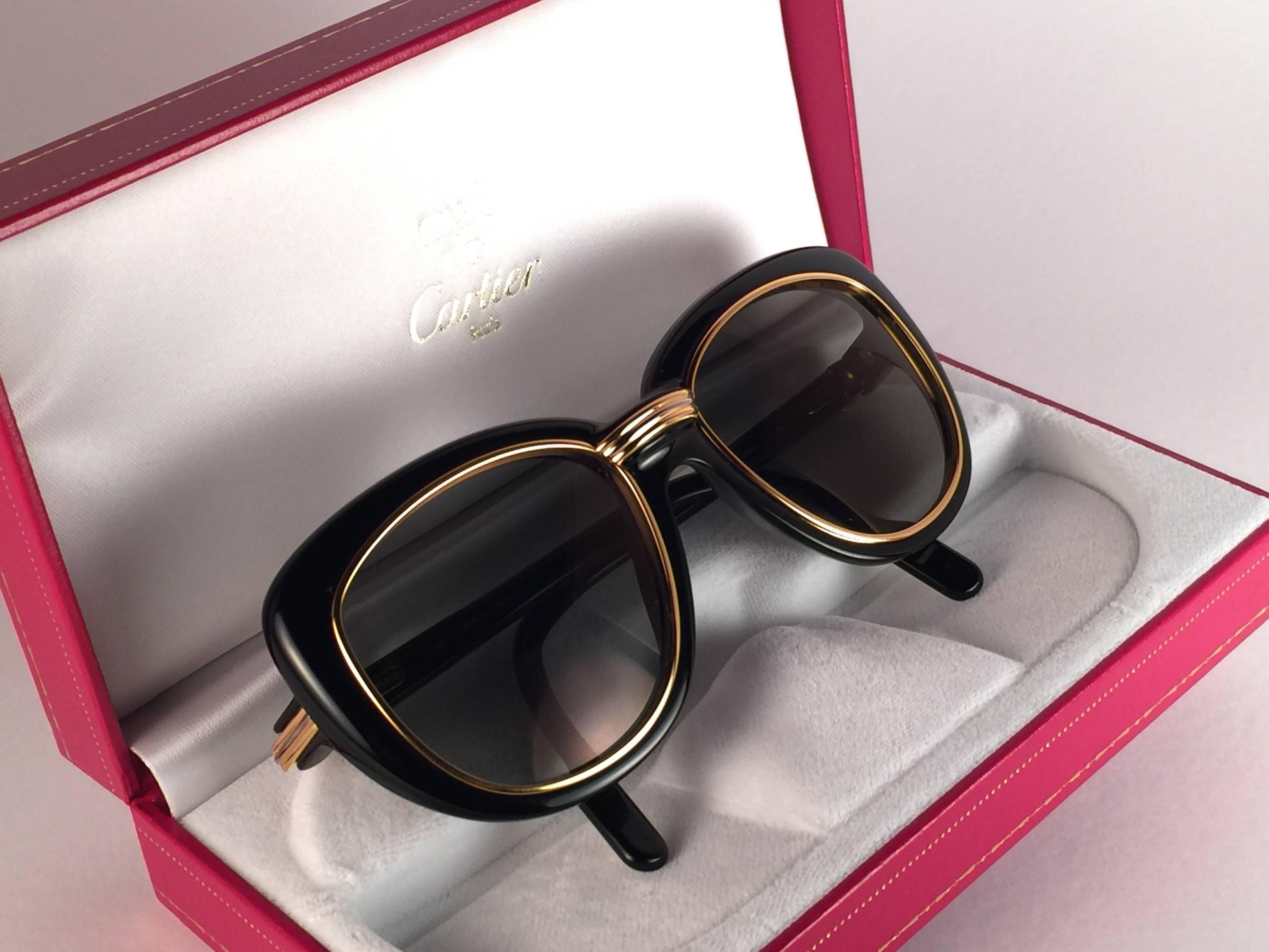 New Cartier Conquete Sunglasses with grey slight gold mirror (uv protection) lenses. Yellow and white gold inserts and accents.  All hallmarks.  Both arms sport the C from Cartier on the temple.  These are like a pair of jewels on your nose with the