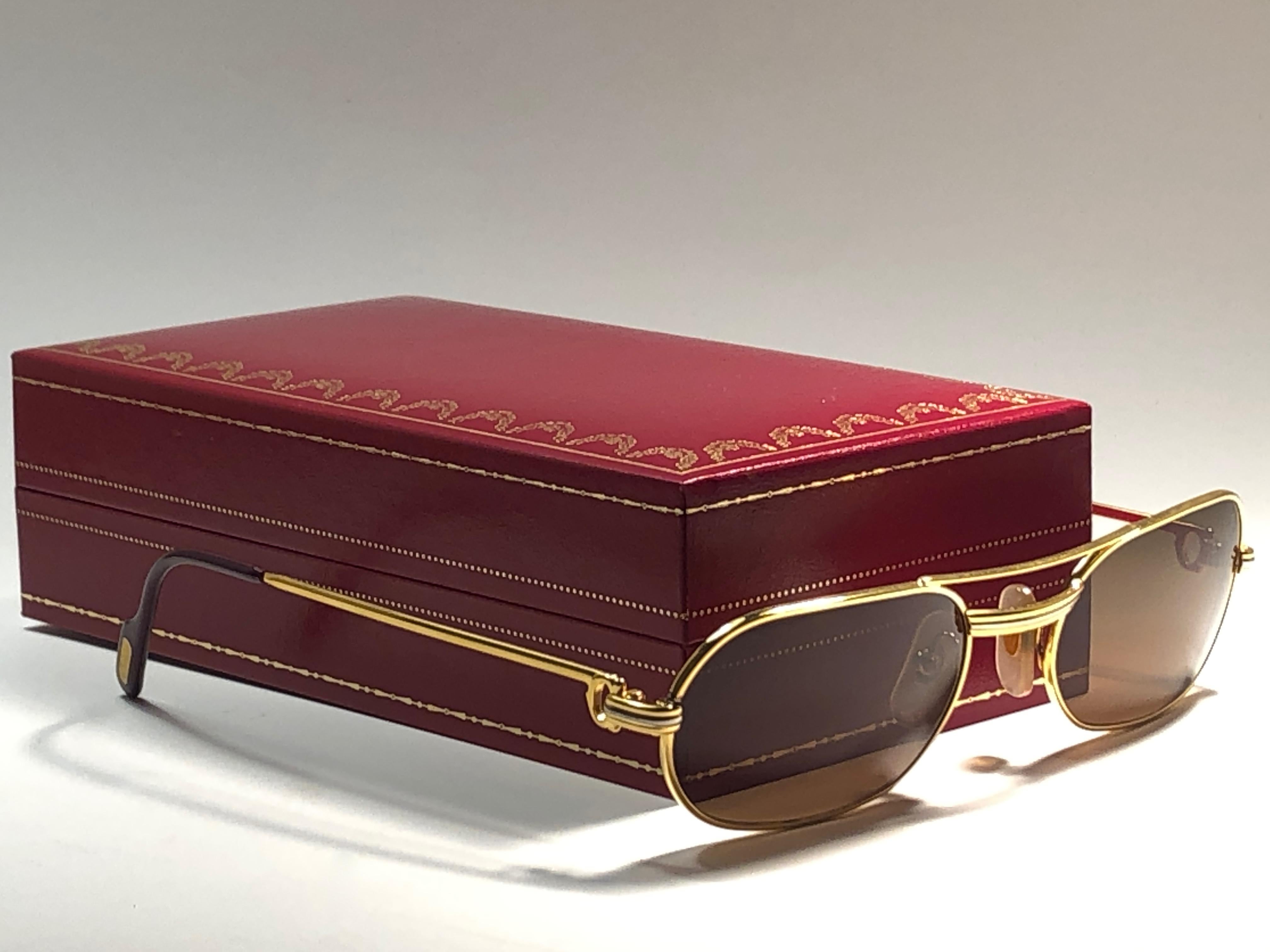 Original 1983 Cartier Santos Vendome sunglasses with new  brown lenses. Frame is with the front and sides in yellow and white gold and the famous santos accents.  
All hallmarks. red enamel with cartier gold signs on the burgundy ear paddles. Both