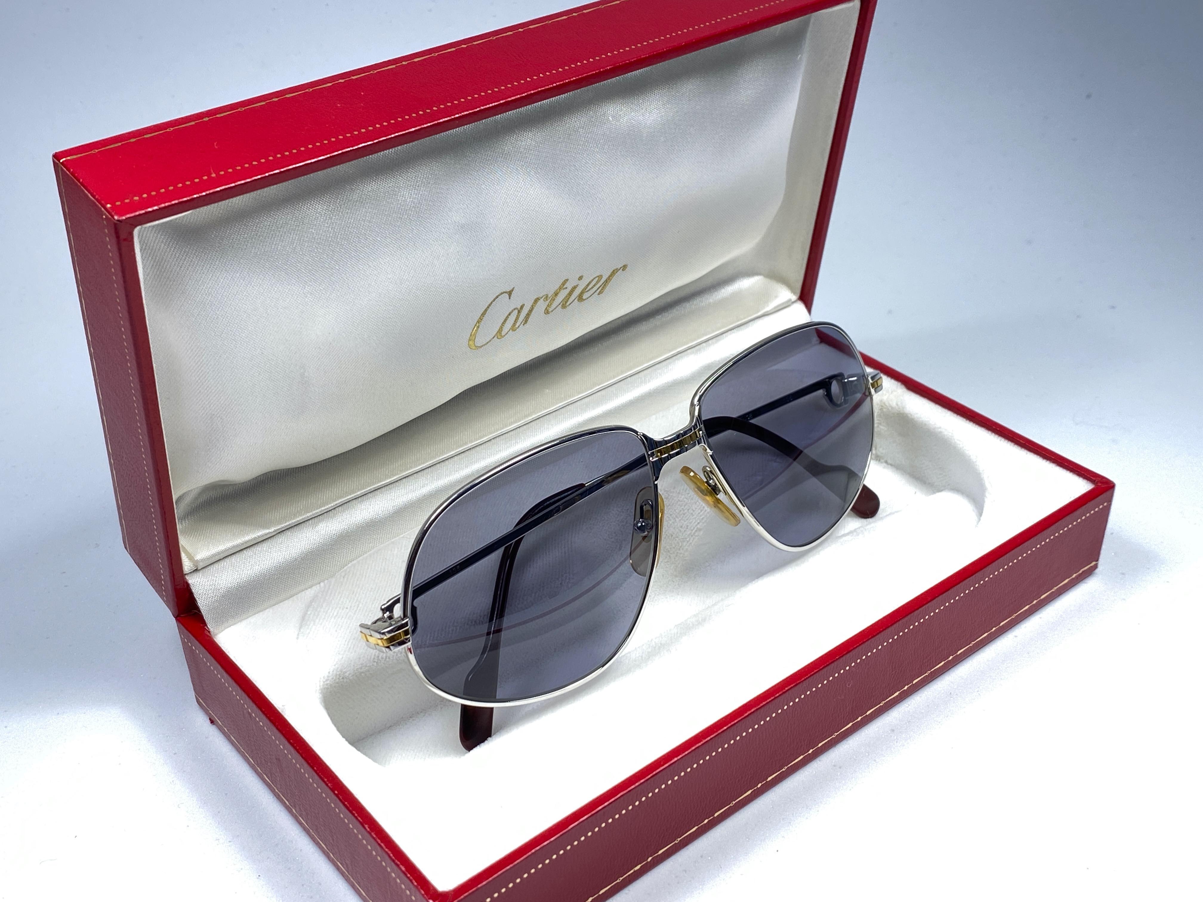 New 1988 Cartier Panthere sunglasses with grey (uv protection) lenses.  
Frame is with the front and sides in yellow and white gold. All hallmarks. burgundy ear paddles. 
Both arms sport the C from Cartier on the temple. 
These are like a pair of