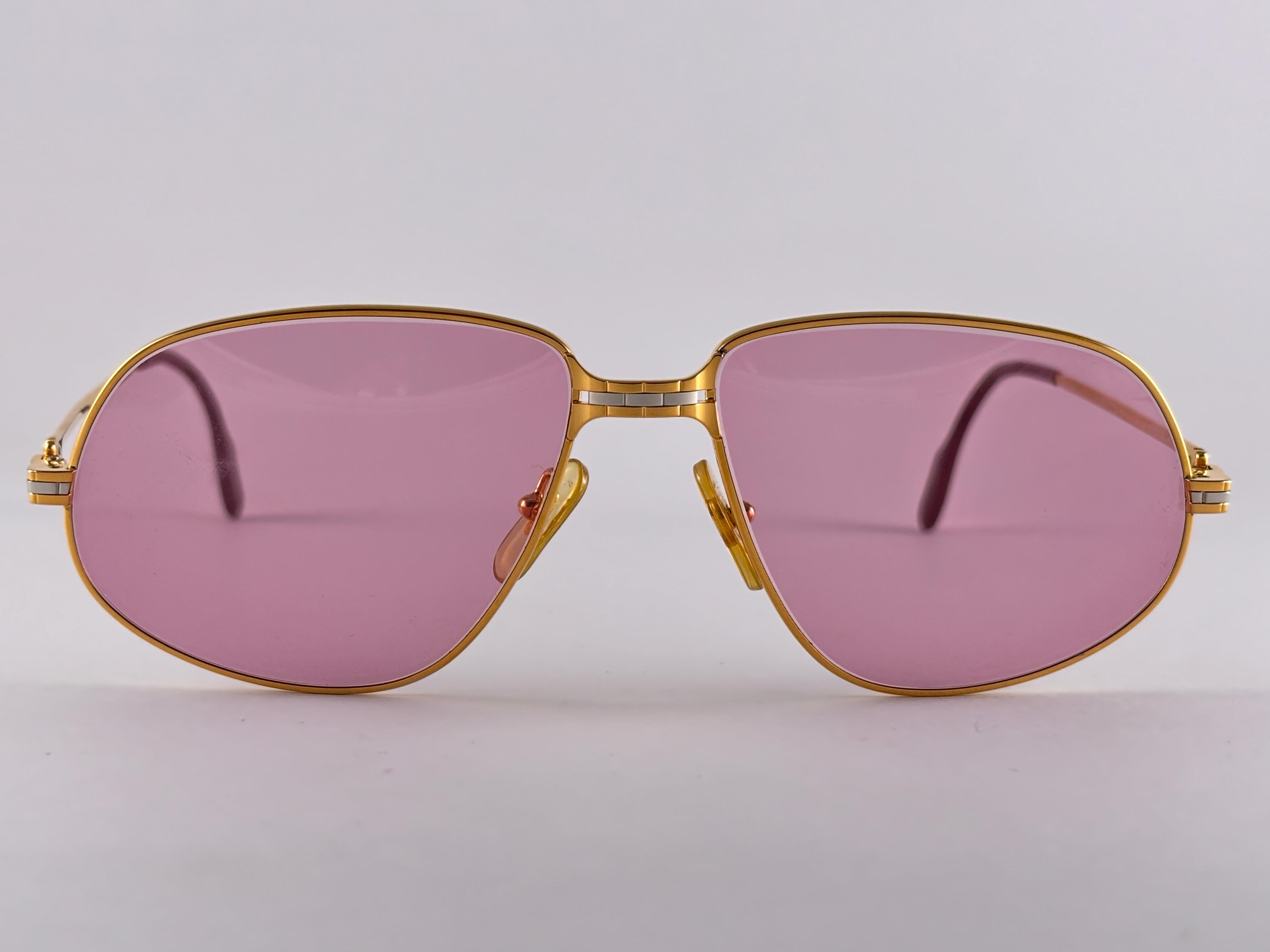 New 1988 Cartier Panthere sunglasses with rose (uv protection) lenses.  Frame is with the front and sides in yellow and white gold. All hallmarks. burgundy ear paddles. 
Both arms sport the C from Cartier on the temple. 
These are like a pair of